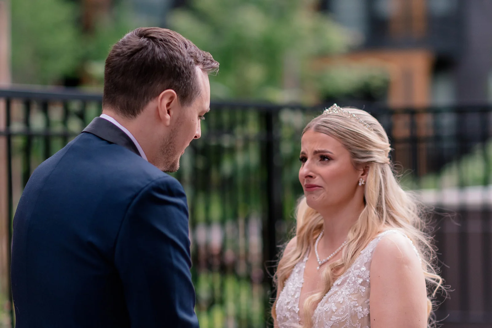 Bride smiling and wiping away tears during the emotional first look with the groom
