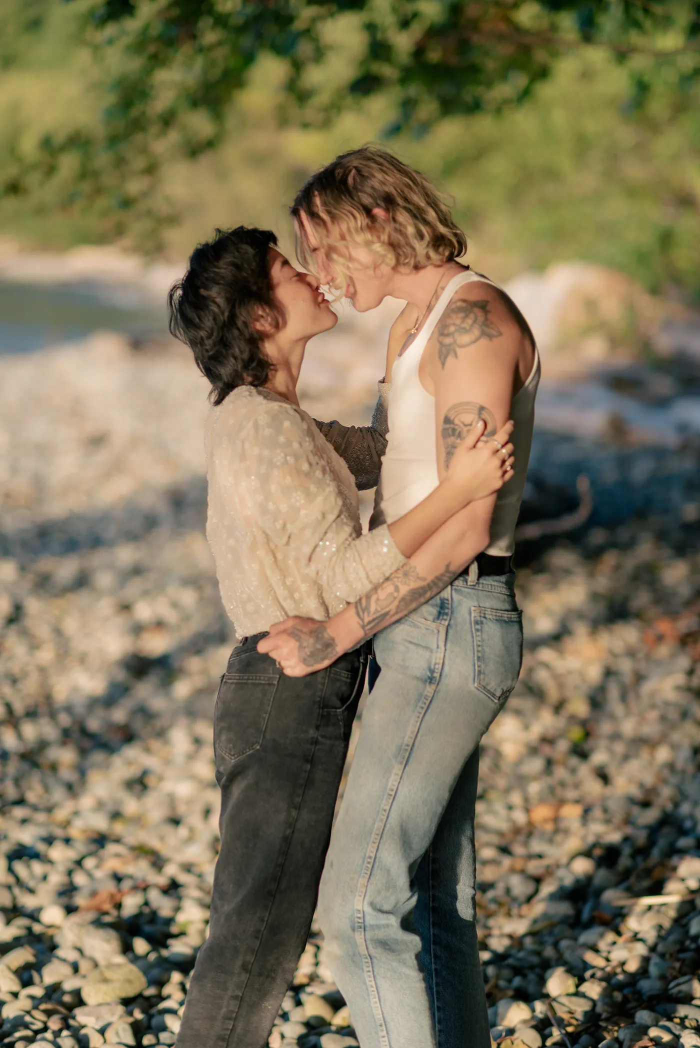 Newly engaged queer couple walking along the shore, celebrating their love. A dreamy and intimate engagement session on a scenic Canadian beach.