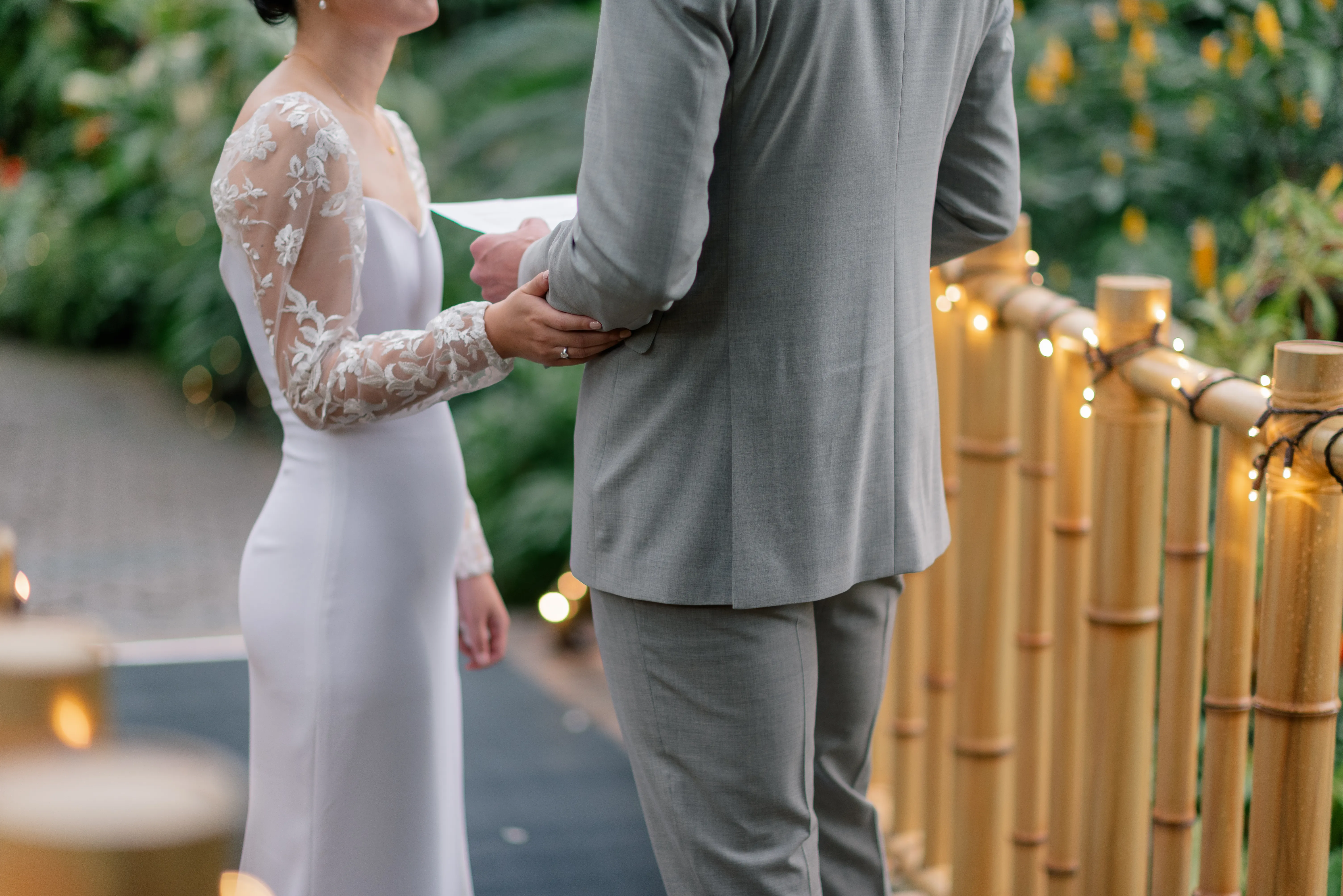 Bride and groom exchanging private vows under the glass dome of Bloedel Conservatory, framed by tropical plants.