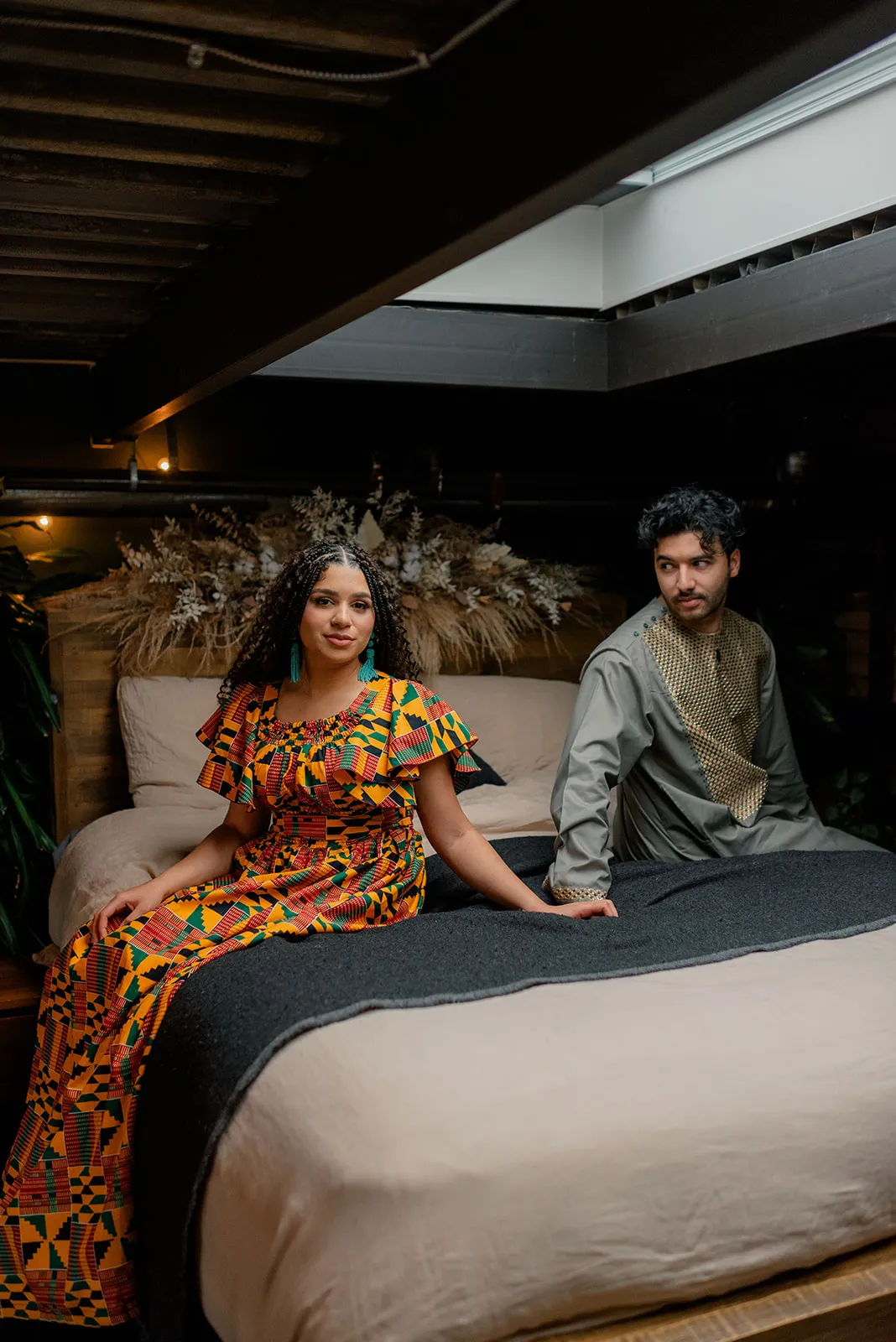 Elegant engagement portrait of C&J at Loft Garden Oasis, with rich colors from their cultural outfits contrasting the earthy studio tones.