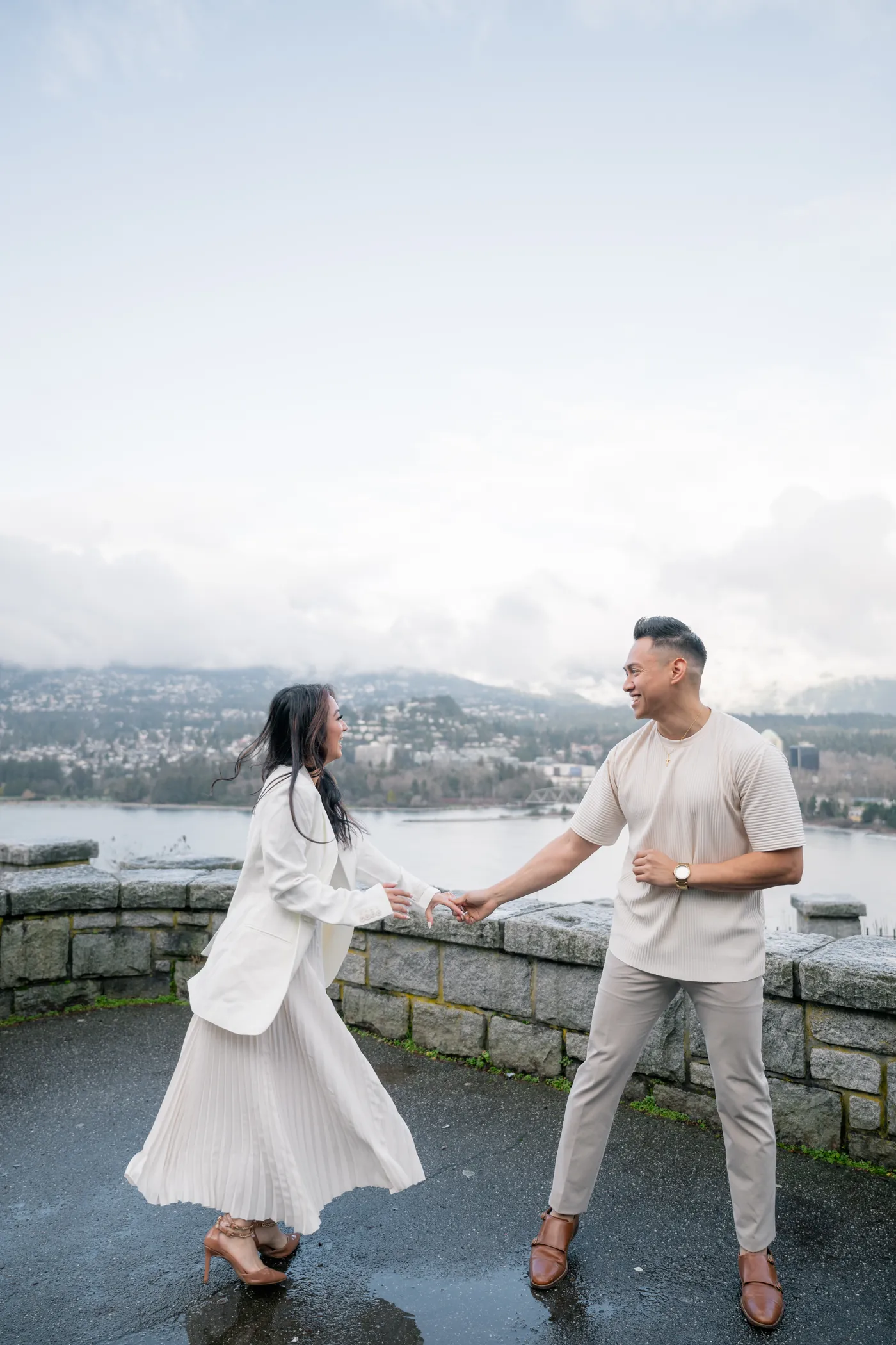 A woman twirls in an elegant pleated skirt during her engagement session at Prospect Point, capturing movement and joy