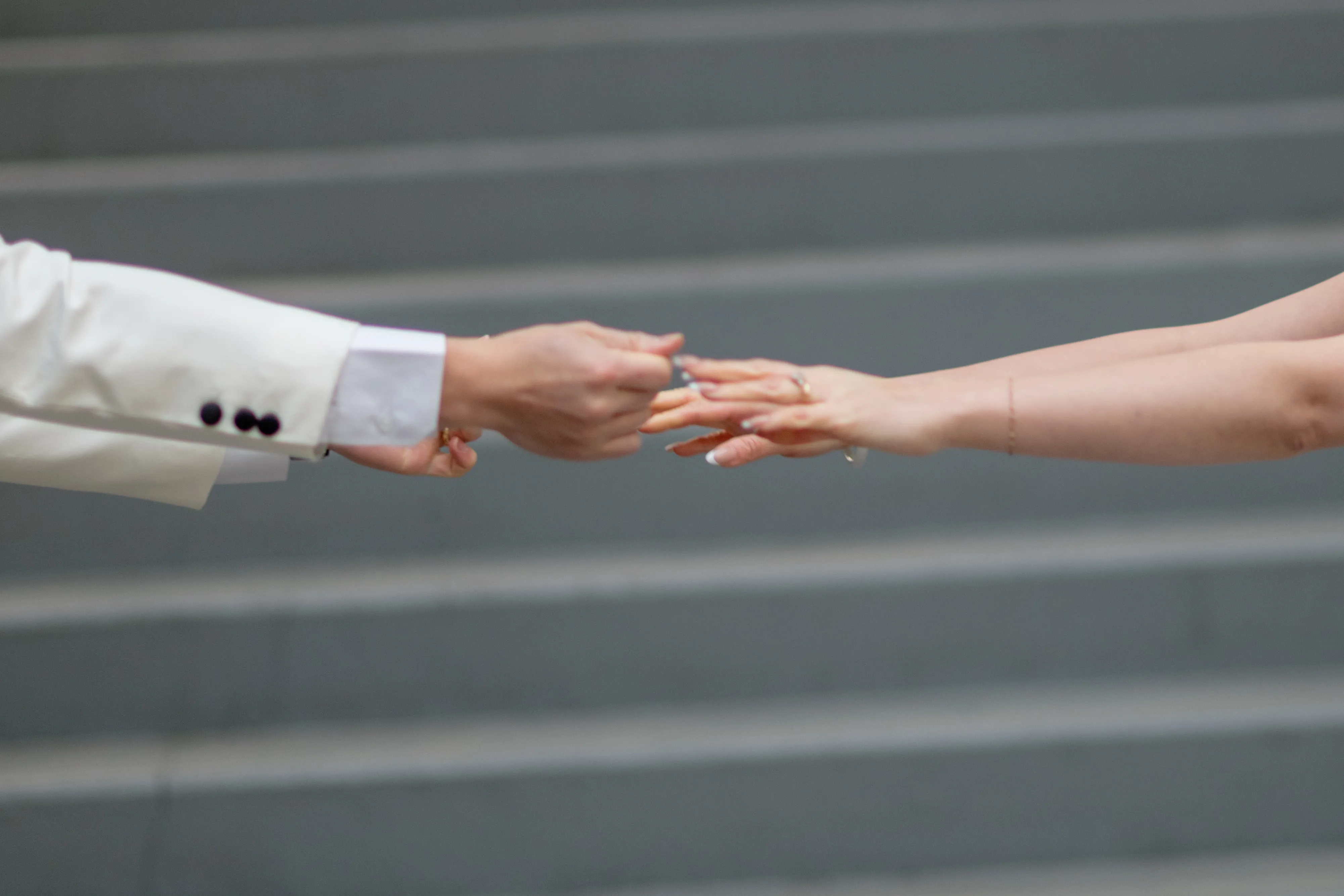 Bride and groom holding hands under glass ceiling at SAIT polytechnic parkade