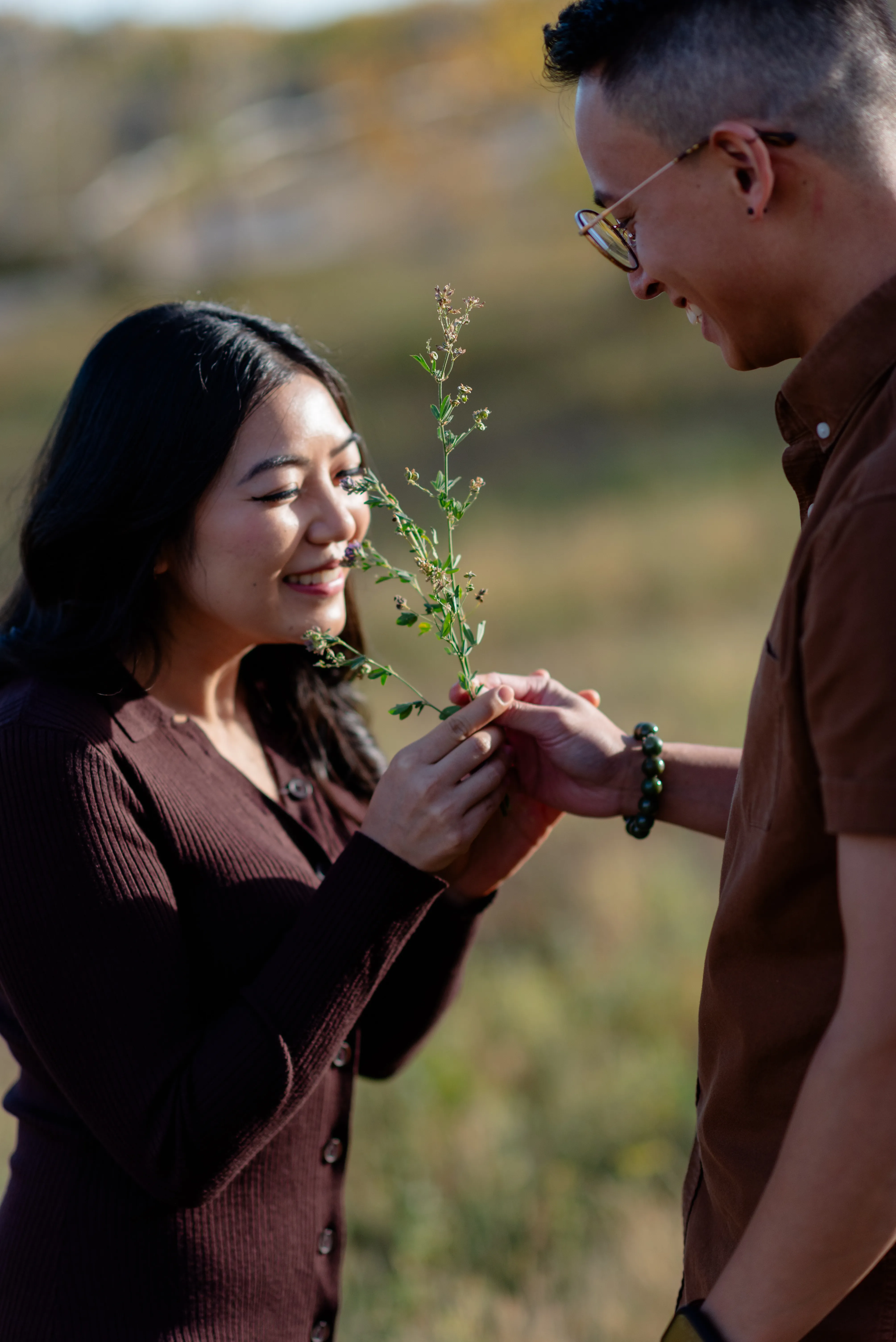 Close-up of couple smelling wildflower together at Evamy Ridge Calgary