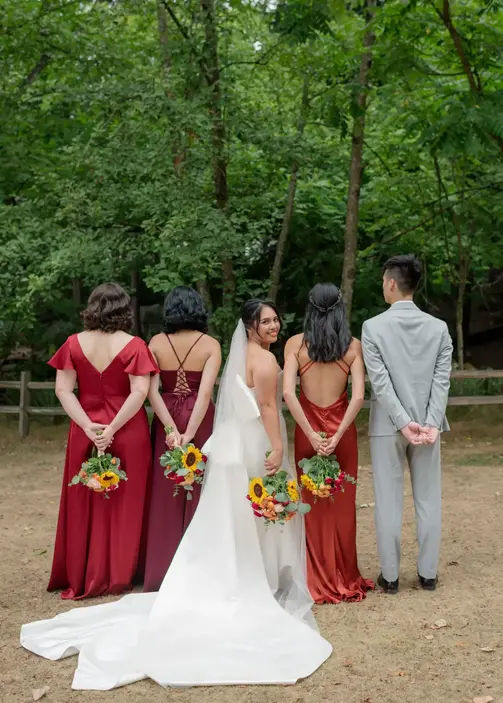 bride posing artistically and candidly with her bridesmaids with back turned away from camera hart house british columbia