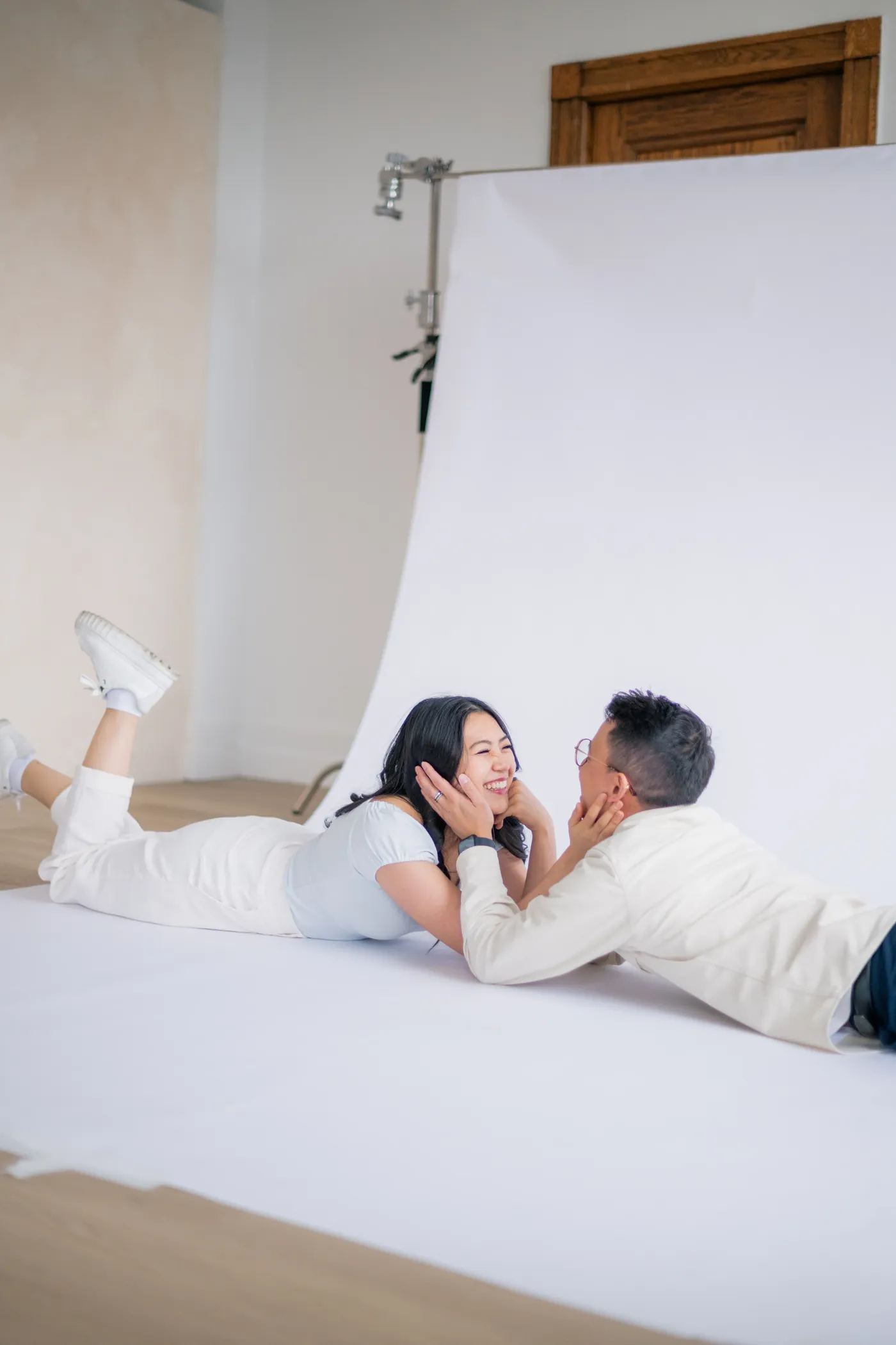 Playful moment captured between a couple leaning into each other, set in a beautiful indoor studio in Vancouver.