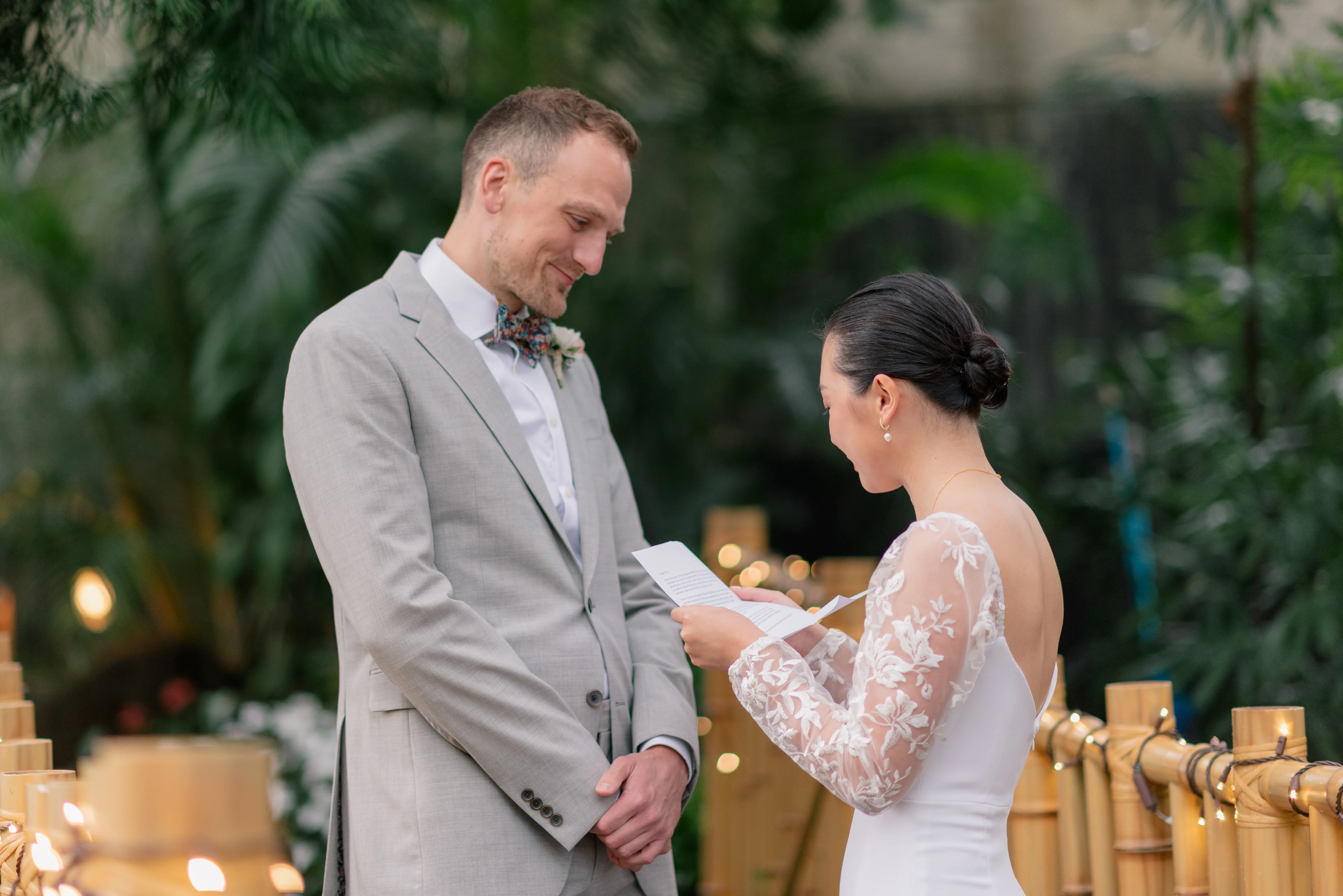 Bride and groom exchanging private vows under the glass dome of Bloedel Conservatory, framed by tropical plants.