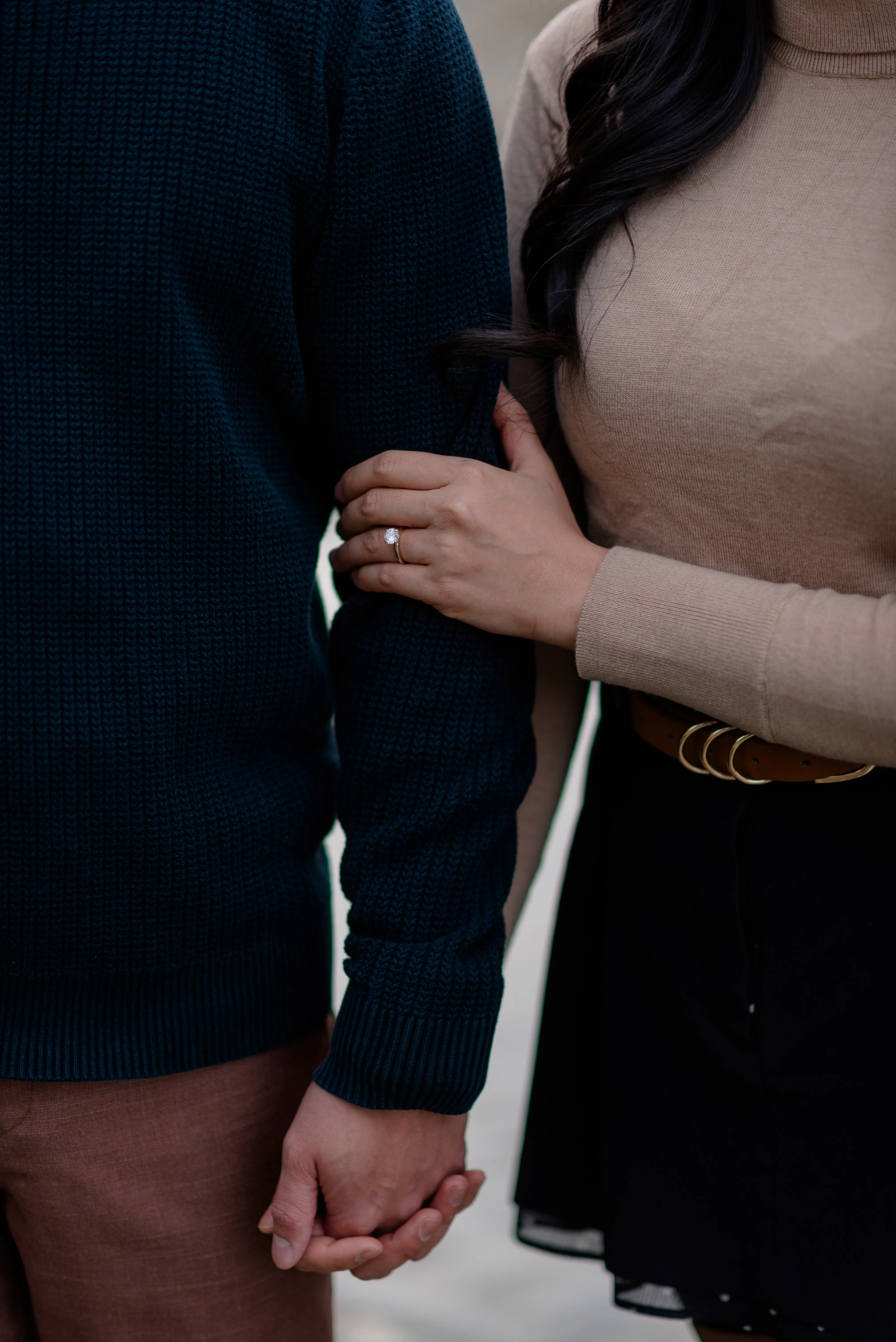 Close-up candid engagement photo of couple smiling together by the river