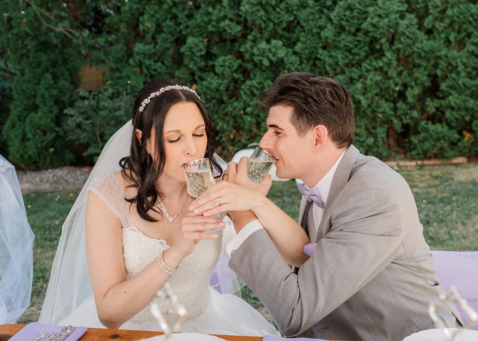 bride and groom sharing a drink at their reception in a summer backyard wedding in mission, british columbia
