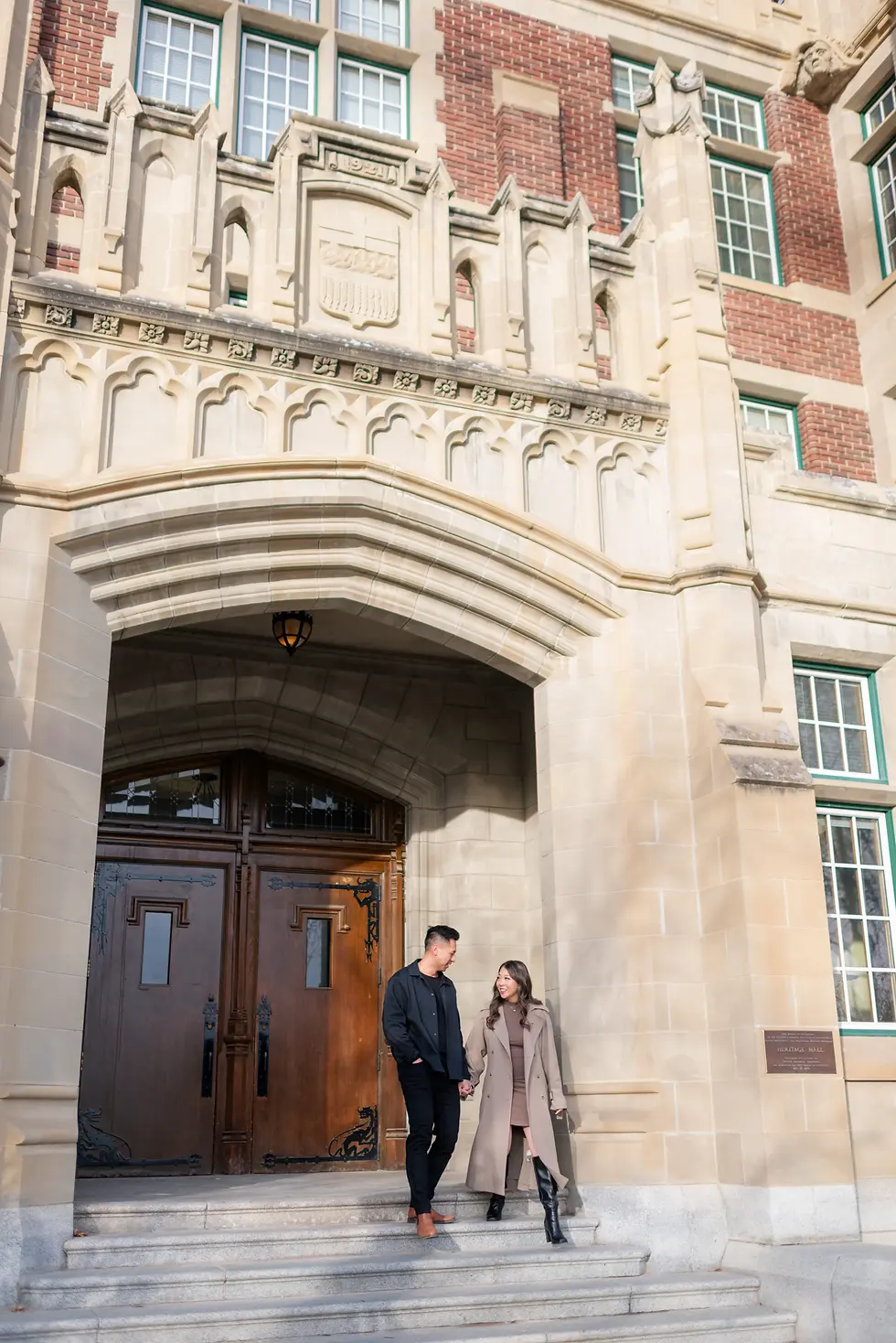 Engagement photo of couple standing close together outside Heritage Hall in Calgary