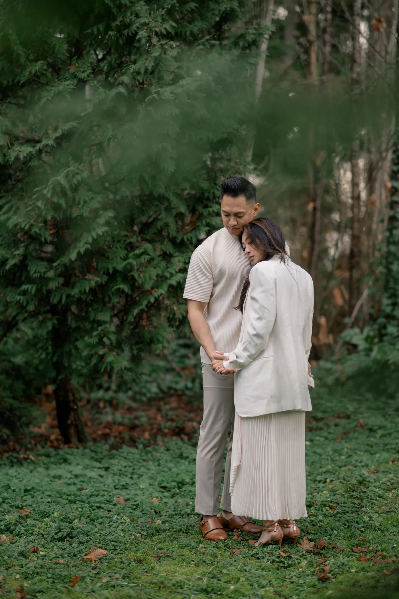 A joyful engagement moment where the groom-to-be lifts his fiancée into the air at Prospect Point in Stanley Park.