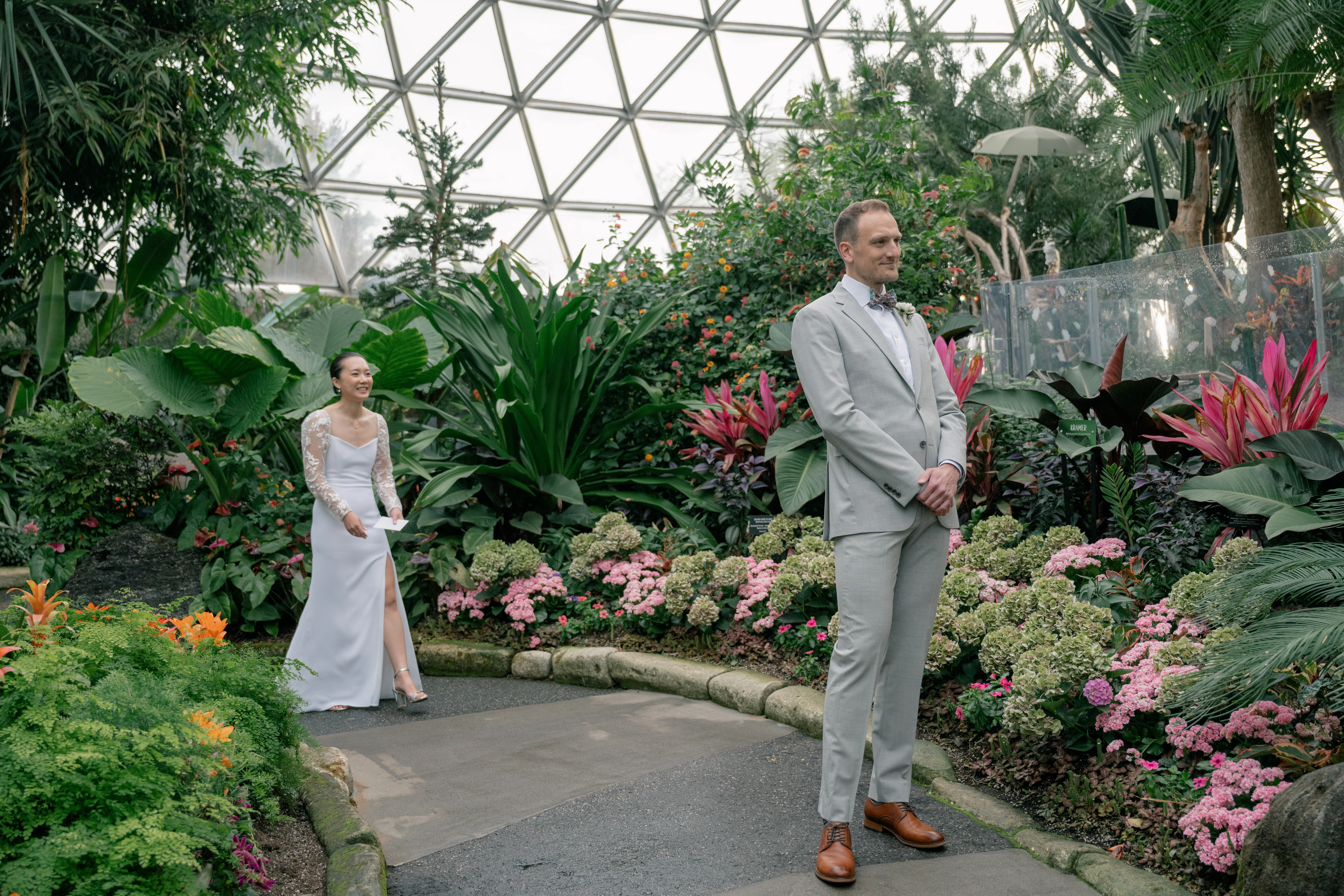 Bride and groom sharing an emotional first look in the tropical setting of Bloedel Conservatory, surrounded by vibrant greenery