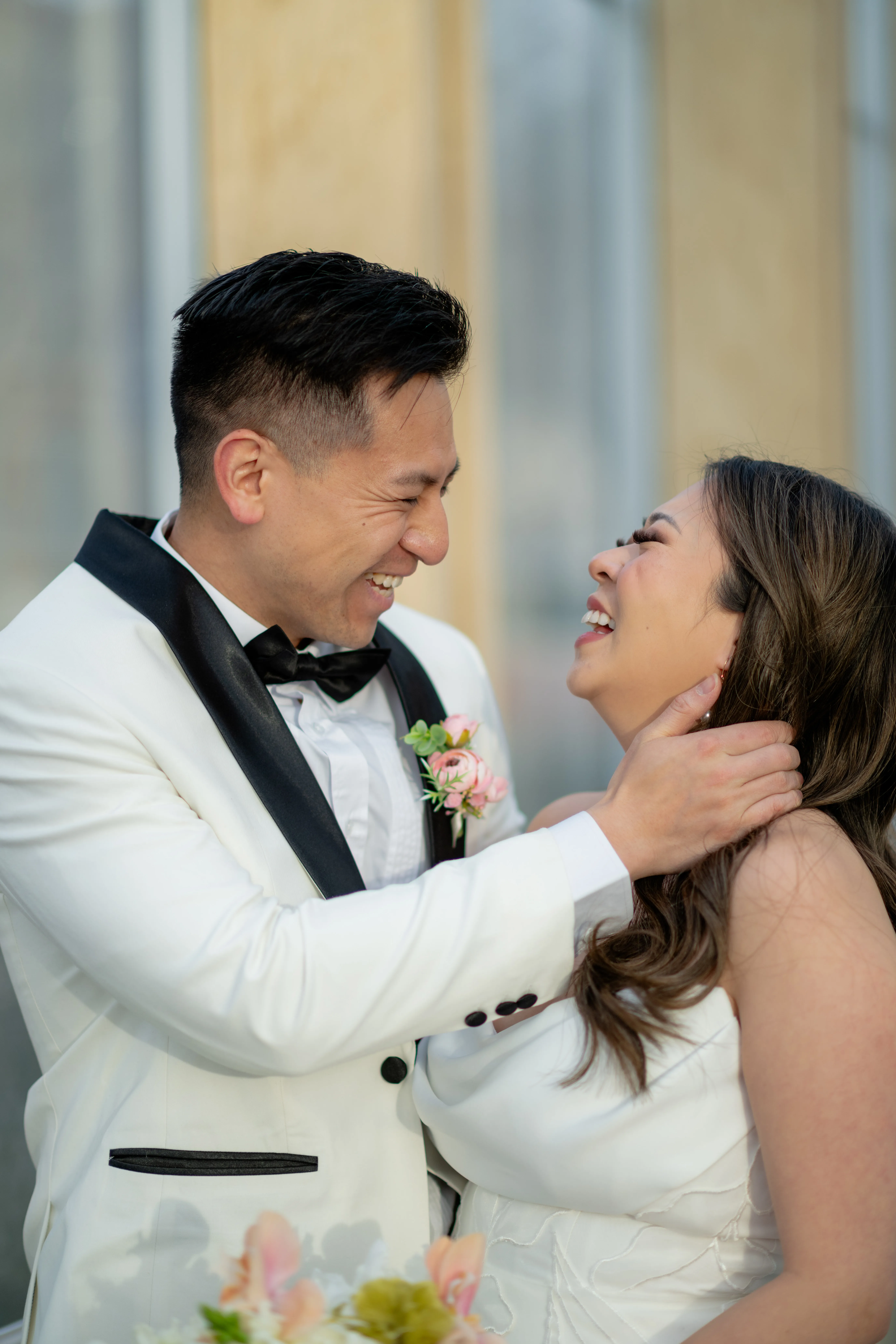 Bride and groom laughing together with city light filtering through parkade