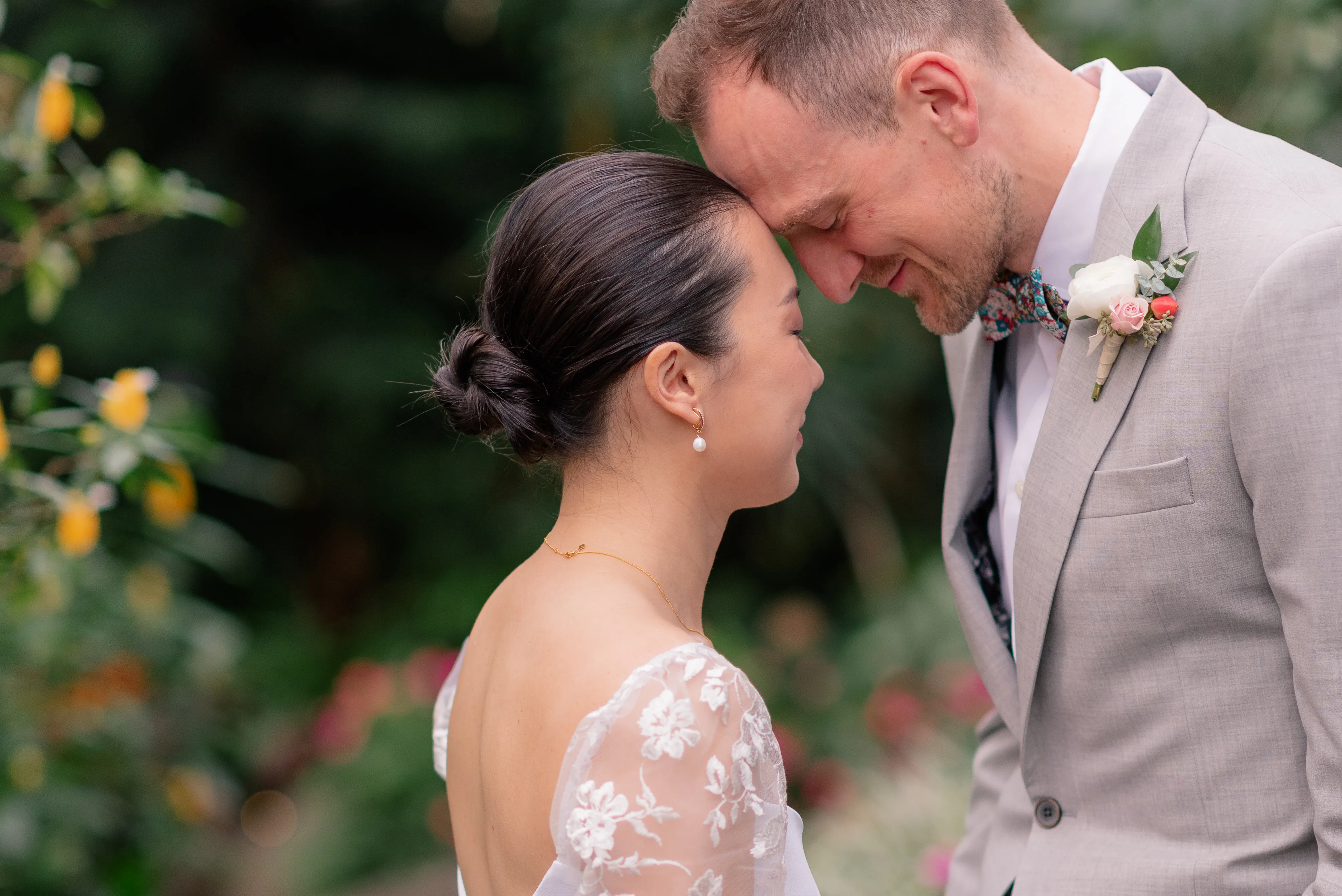 Bride and groom embracing among the tropical plants inside Bloedel Conservatory, surrounded by lush greenery