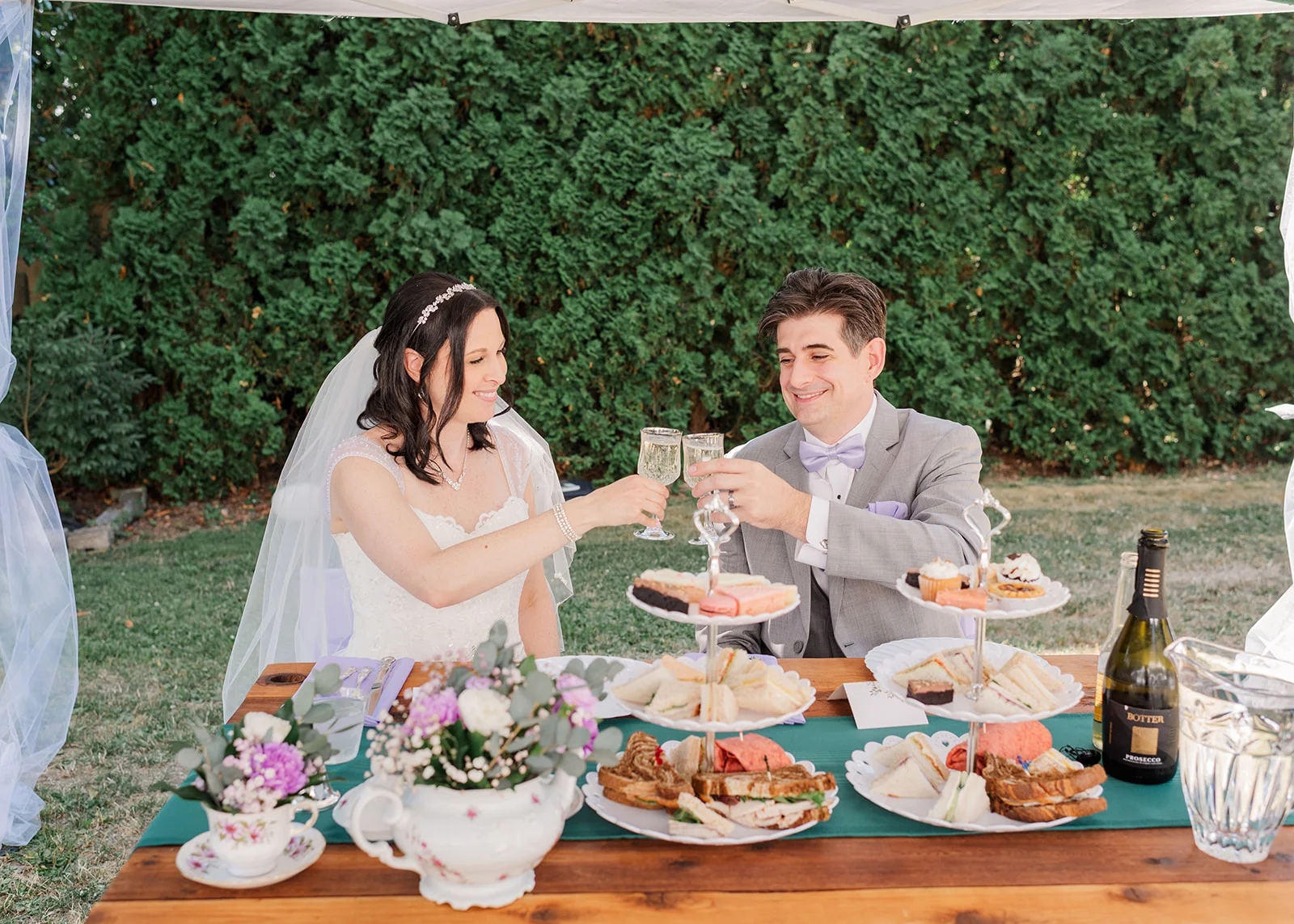 bride and groom sharing a drink at their reception in a summer backyard wedding in mission, british columbia
