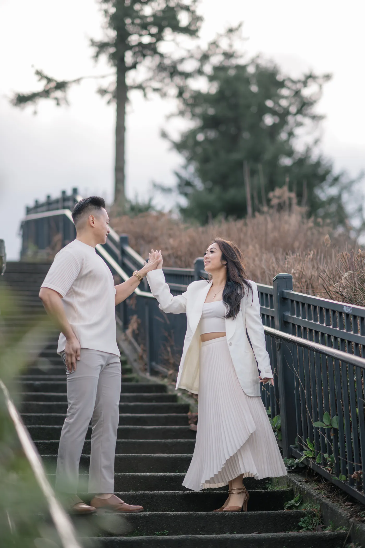 A couple twirls on a set of stone stairs, creating movement and elegance in their engagement session