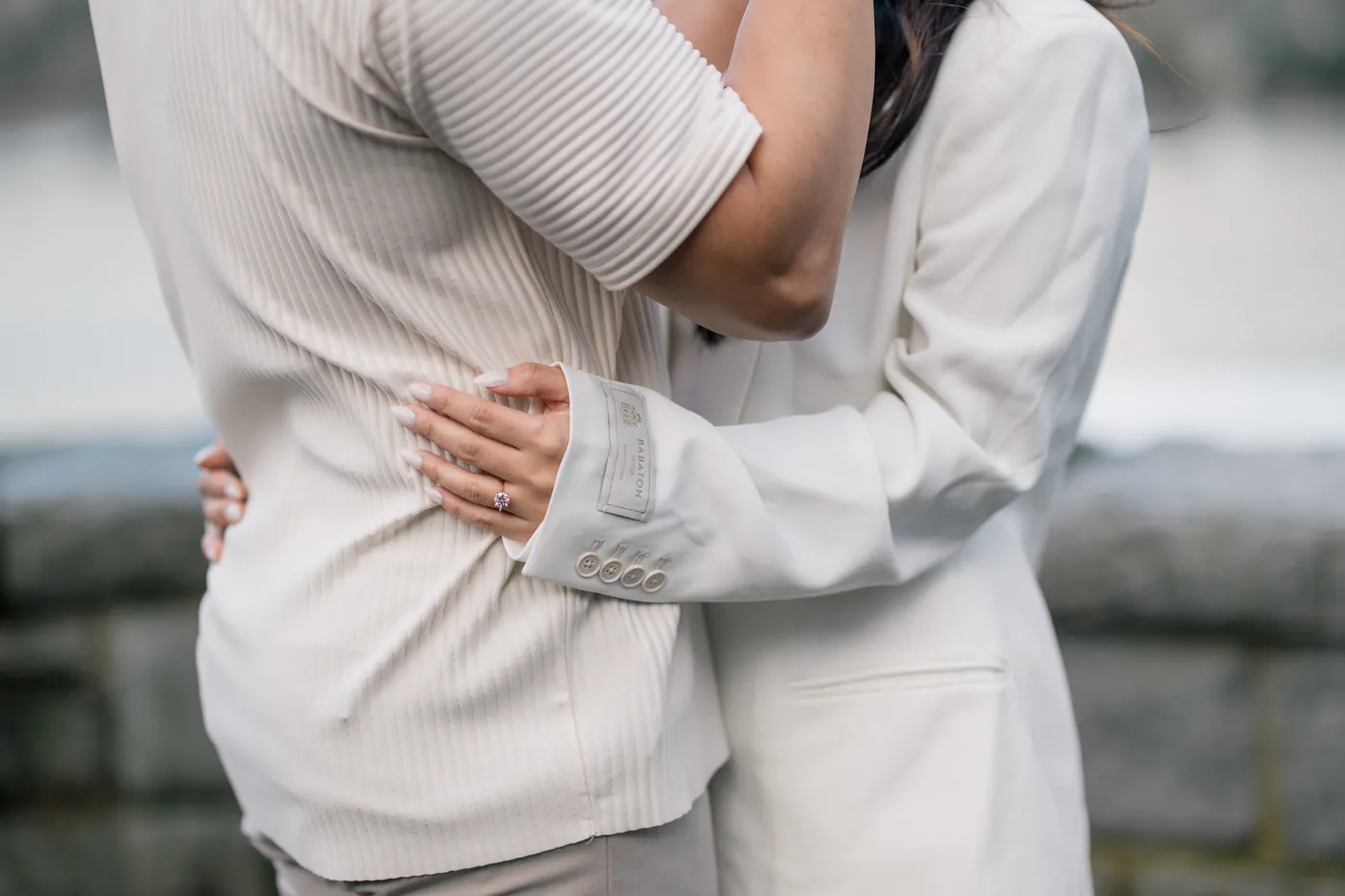 A man kisses his fiancée’s forehead while holding her close, creating an emotional and tender engagement portrait
