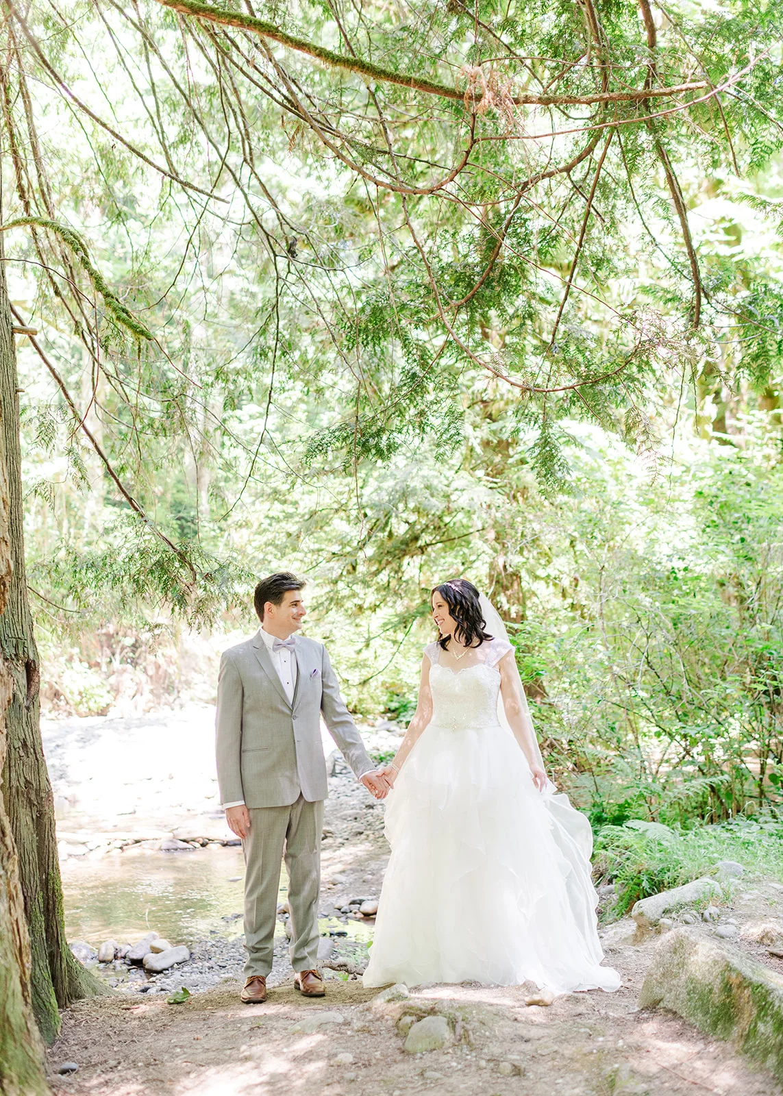 bride and groom holding hands in forest in mission, british columbia