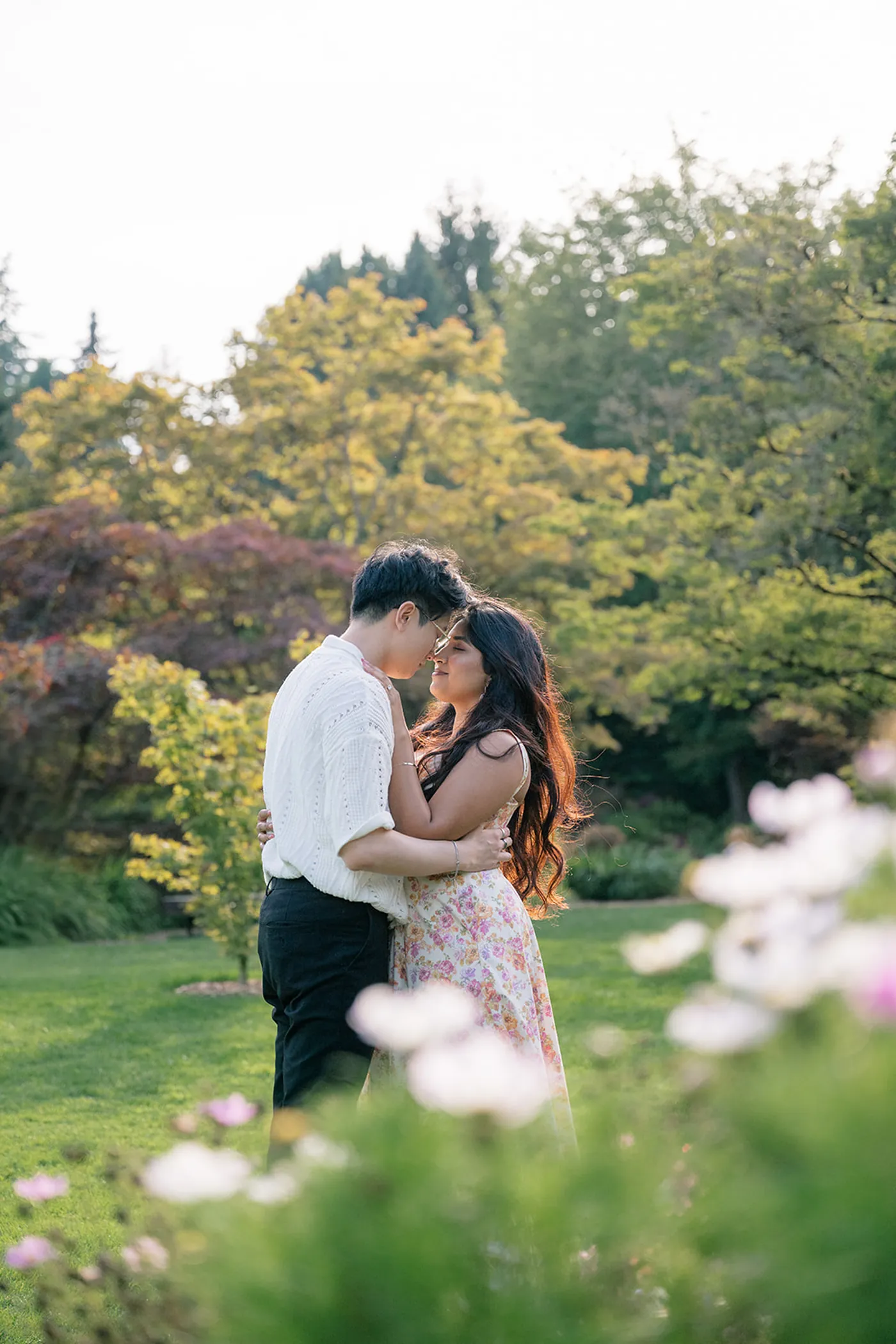 Man and woman walking through the vibrant flower beds of VanDusen Garden after a surprise proposal.