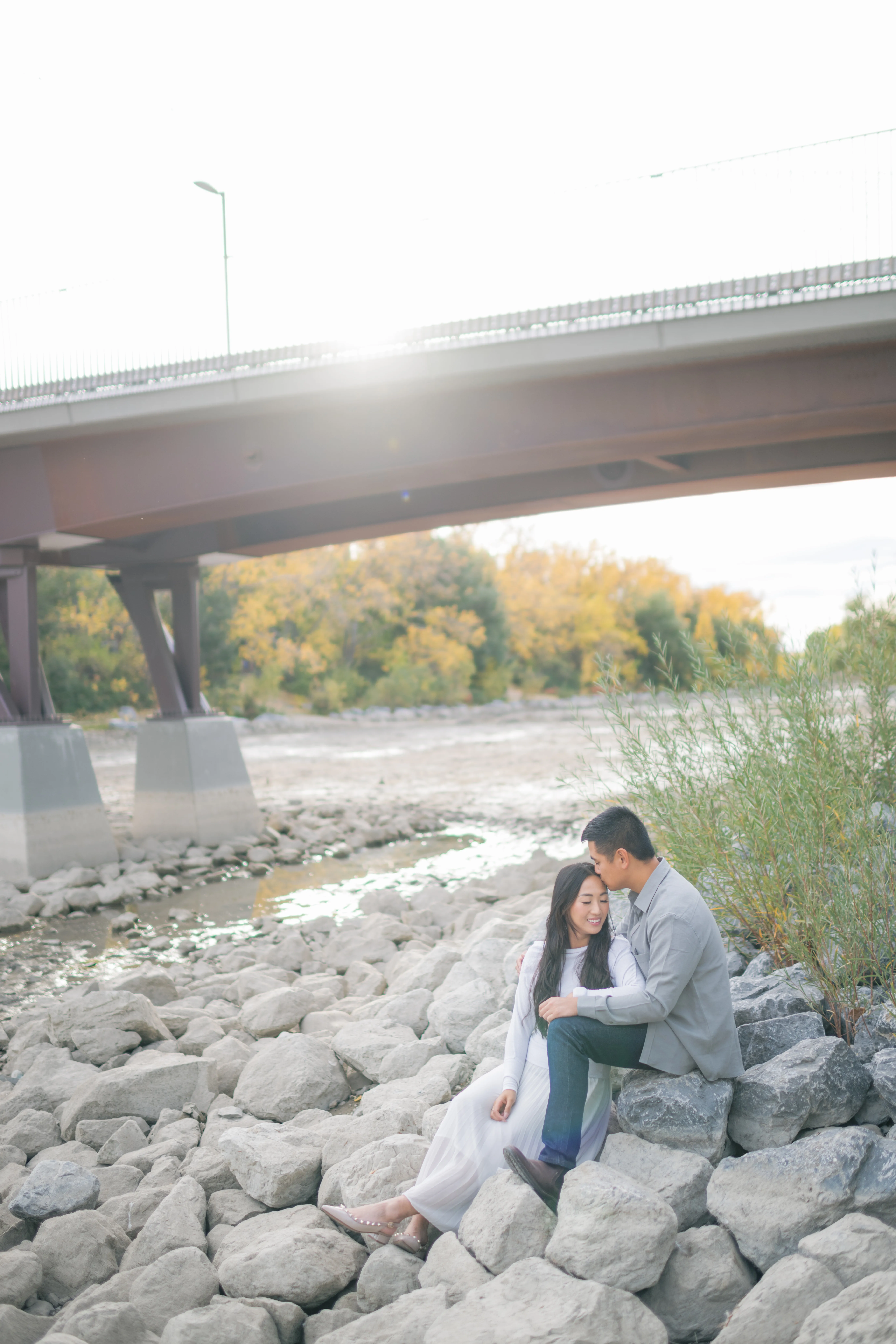 Candid couple forehead kiss in Prince’s Island Park Calgary park