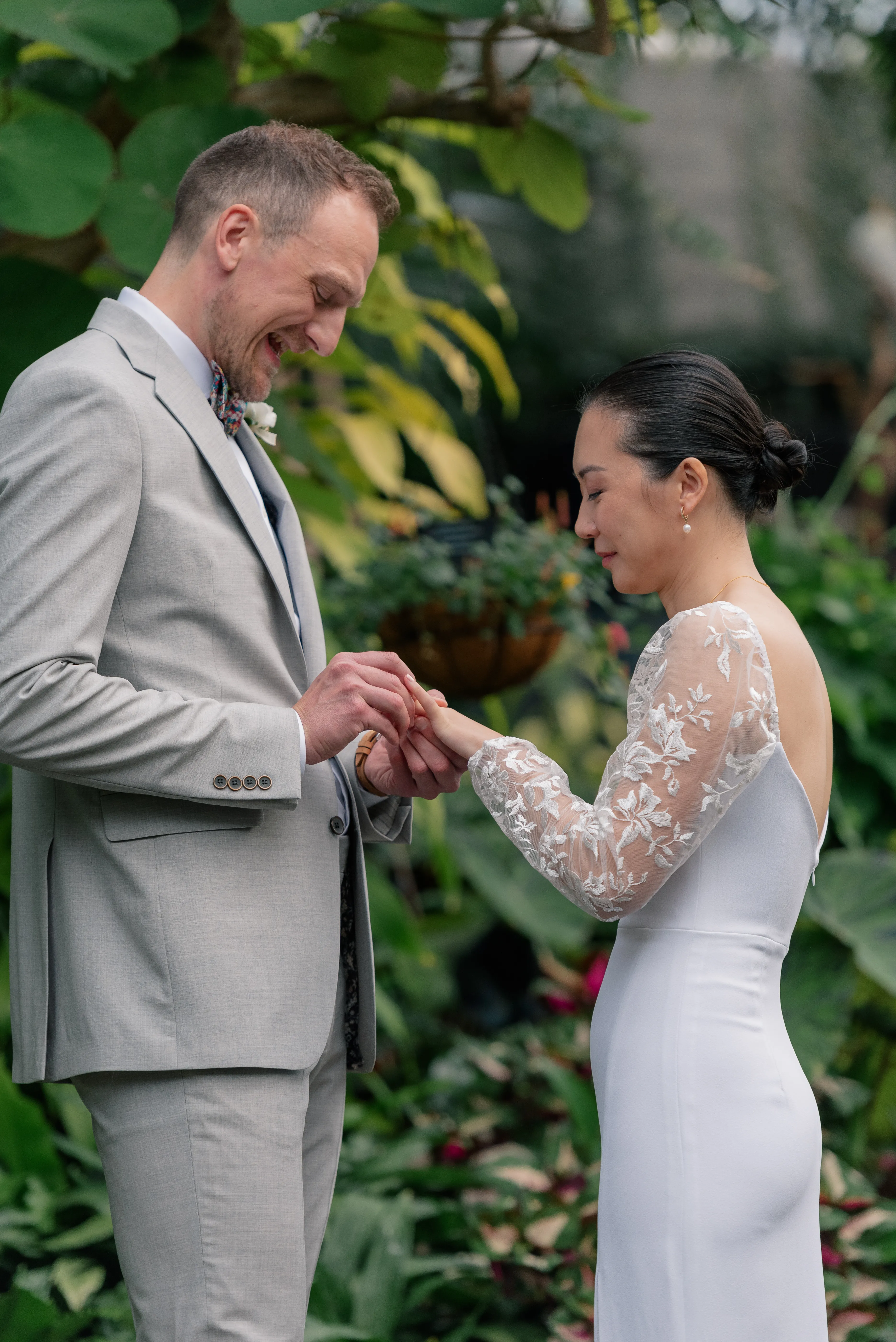 Wedding ceremony at Bloedel Conservatory, with guests seated among vibrant plants and the couple standing at the altar.