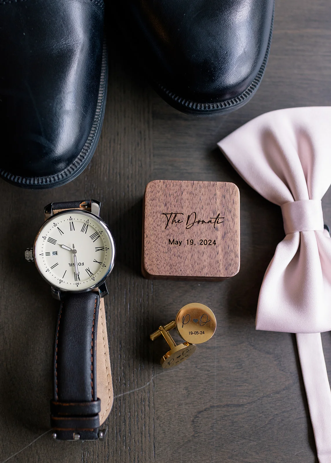 Groom arranging his tie, watch, and other accessories before the ceremony