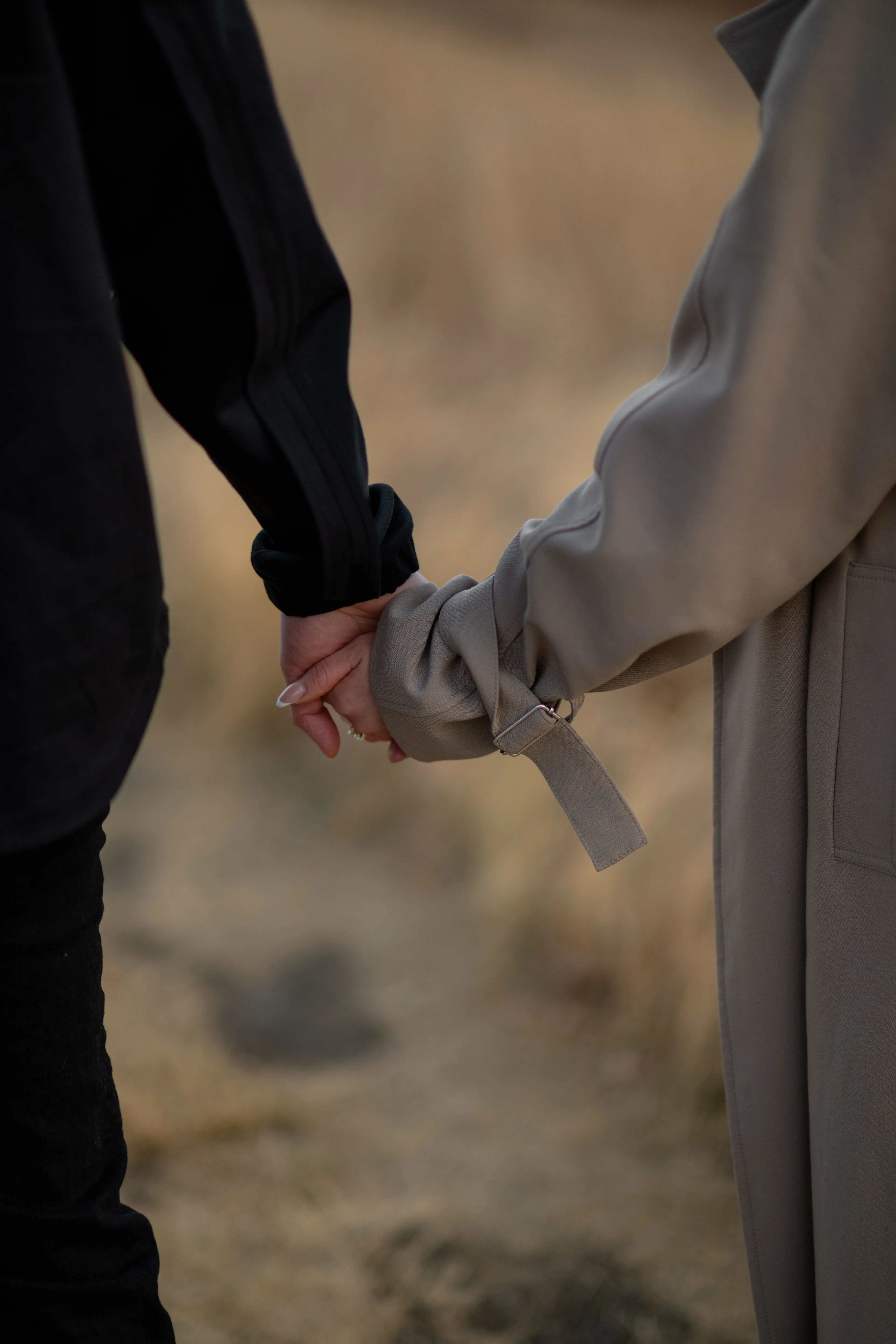 Close-up detail of couple holding hands during engagement photoshoot in Calgary