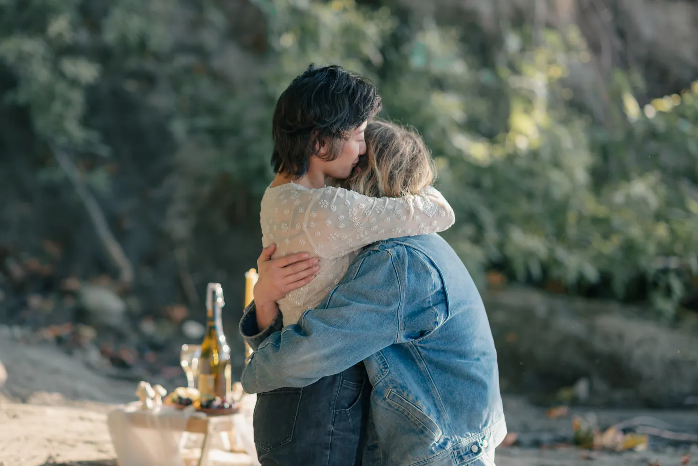 An emotional moment as a newly engaged queer couple embraces after a heartfelt proposal in a scenic Canadian outdoor setting. Captured by a professional engagement photographer in Canada.