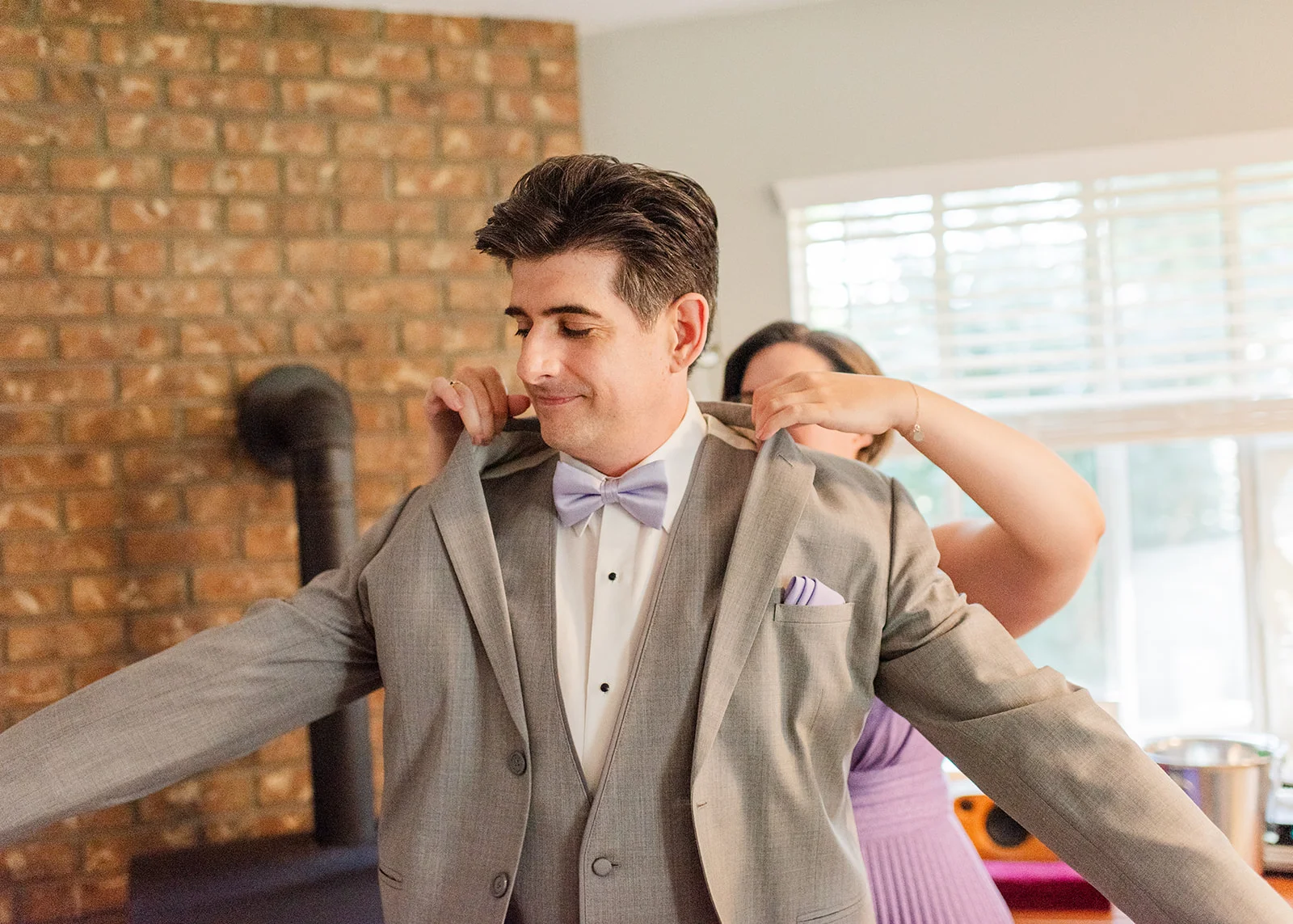 sister helping groom get ready on his wedding day in mission, british columbia