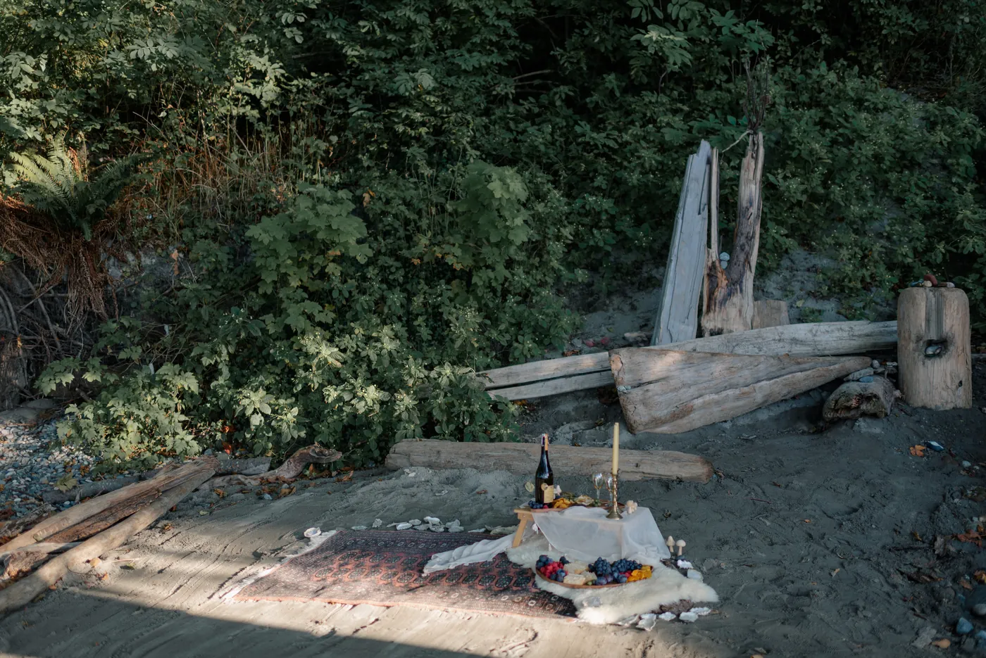 A romantic outdoor picnic proposal in Canada, set in a lush forest with a bottle of champagne and candlelit ambiance. Captured by a Canadian proposal photographer specializing in LGBTQ+ and queer couples.