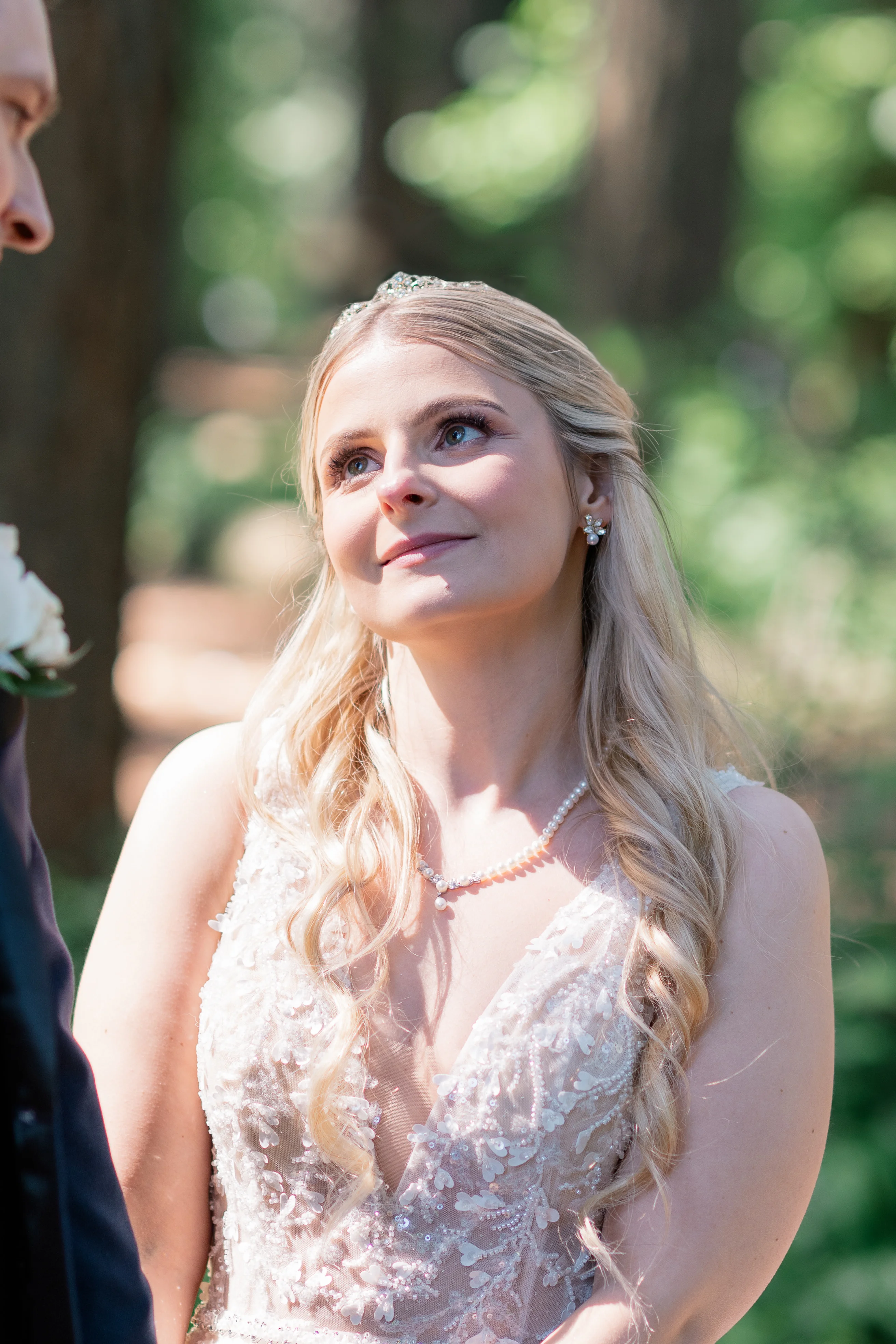Magical couple portraits in a serene forest setting, with the bride and groom surrounded by towering trees and dappled sunlight