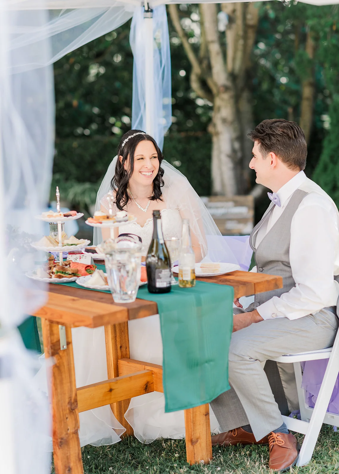 bride and groom sharing a drink at their reception in a summer backyard wedding in mission, british columbia