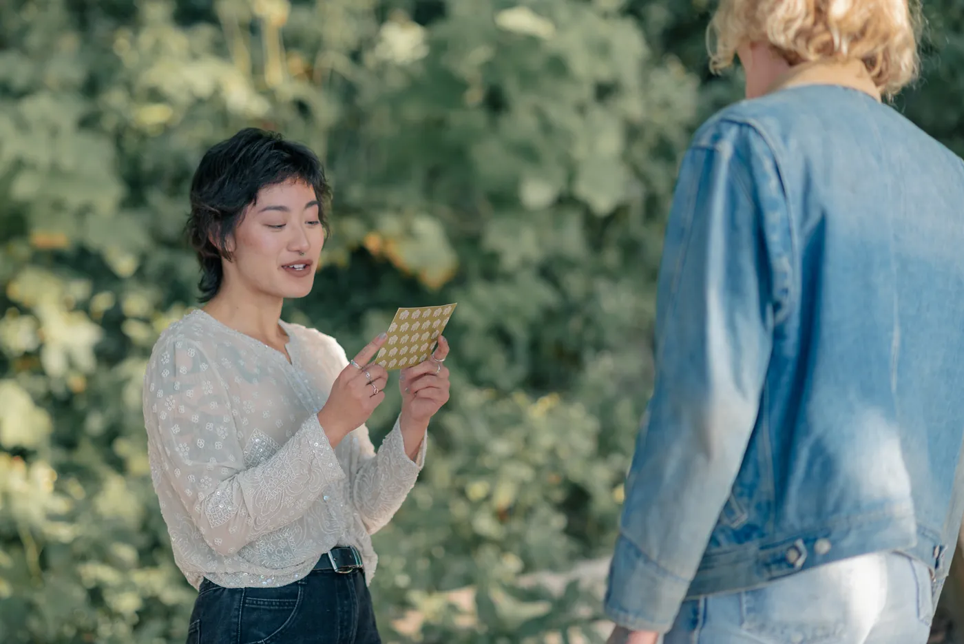 A heartfelt moment as one partner reads a handwritten love note during a surprise proposal in the Canadian outdoors. This intimate proposal was beautifully documented by a queer-friendly engagement photographer in Canada.