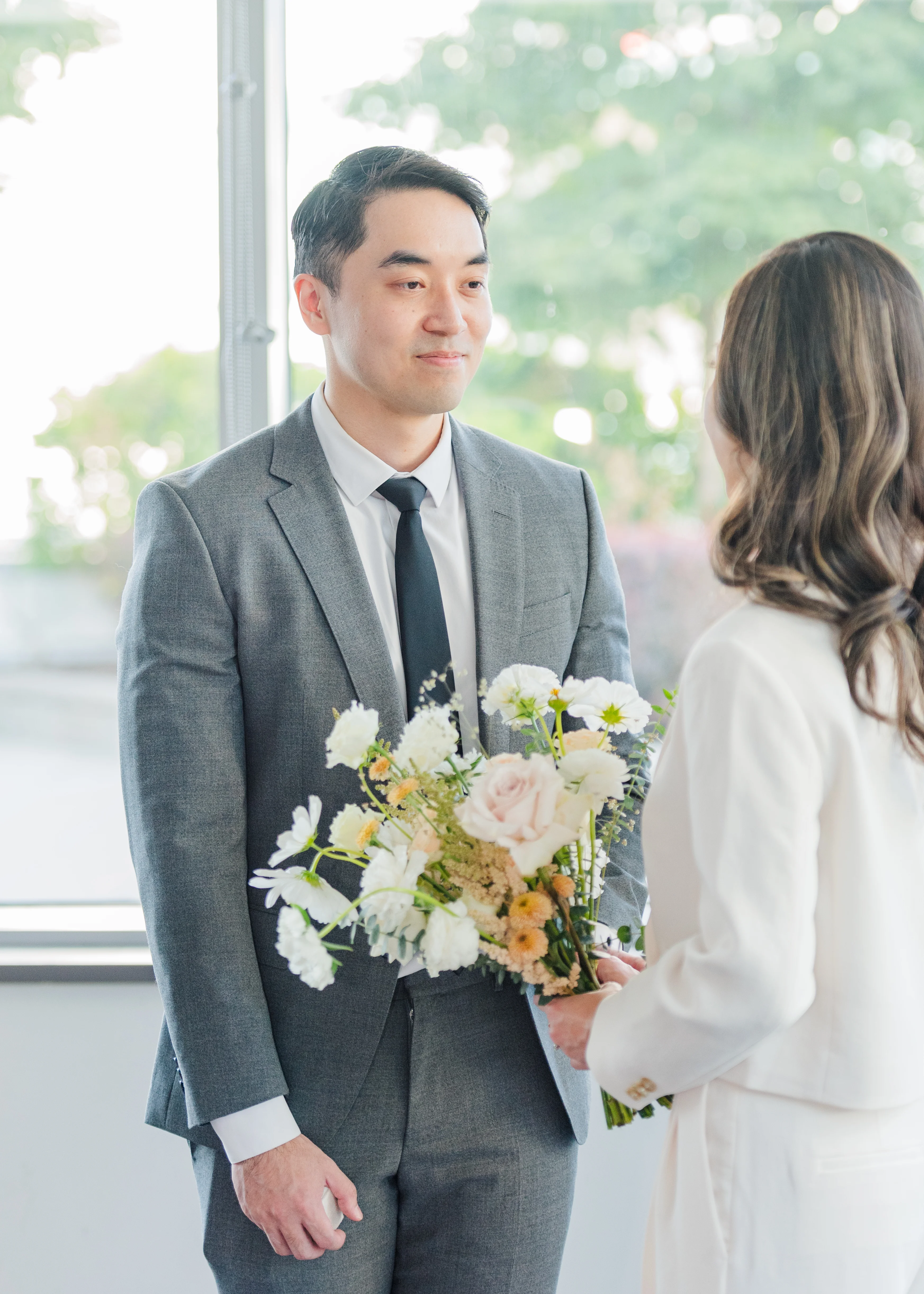 groom looking at bride during civil ceremony in amenities room in Burnaby, B.C.