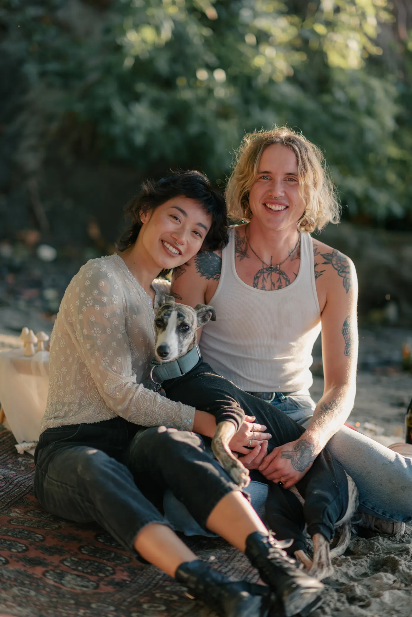 An adventurous LGBTQ+ couple with their dog enjoying a champagne toast in nature. A heartwarming post-proposal celebration by a Canadian queer engagement photographer.