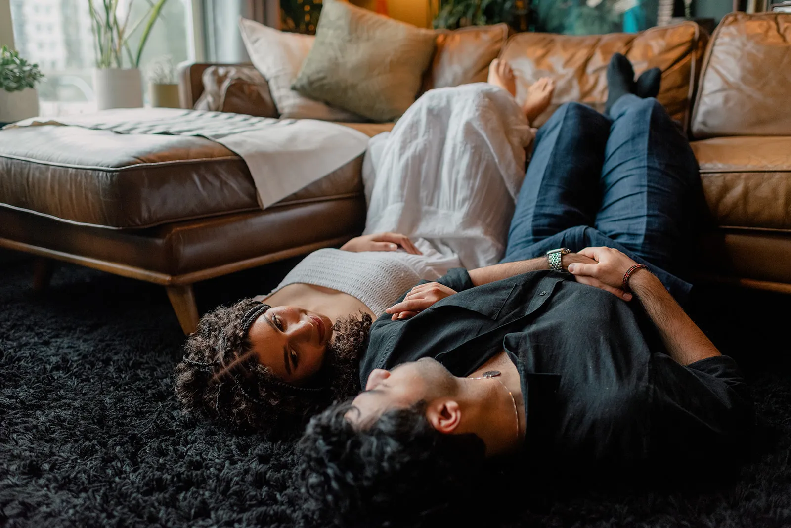 Couple lying together on a textured rug at Loft Garden Oasis, showcasing intimate moments and a cozy Vancouver photoshoot setting.