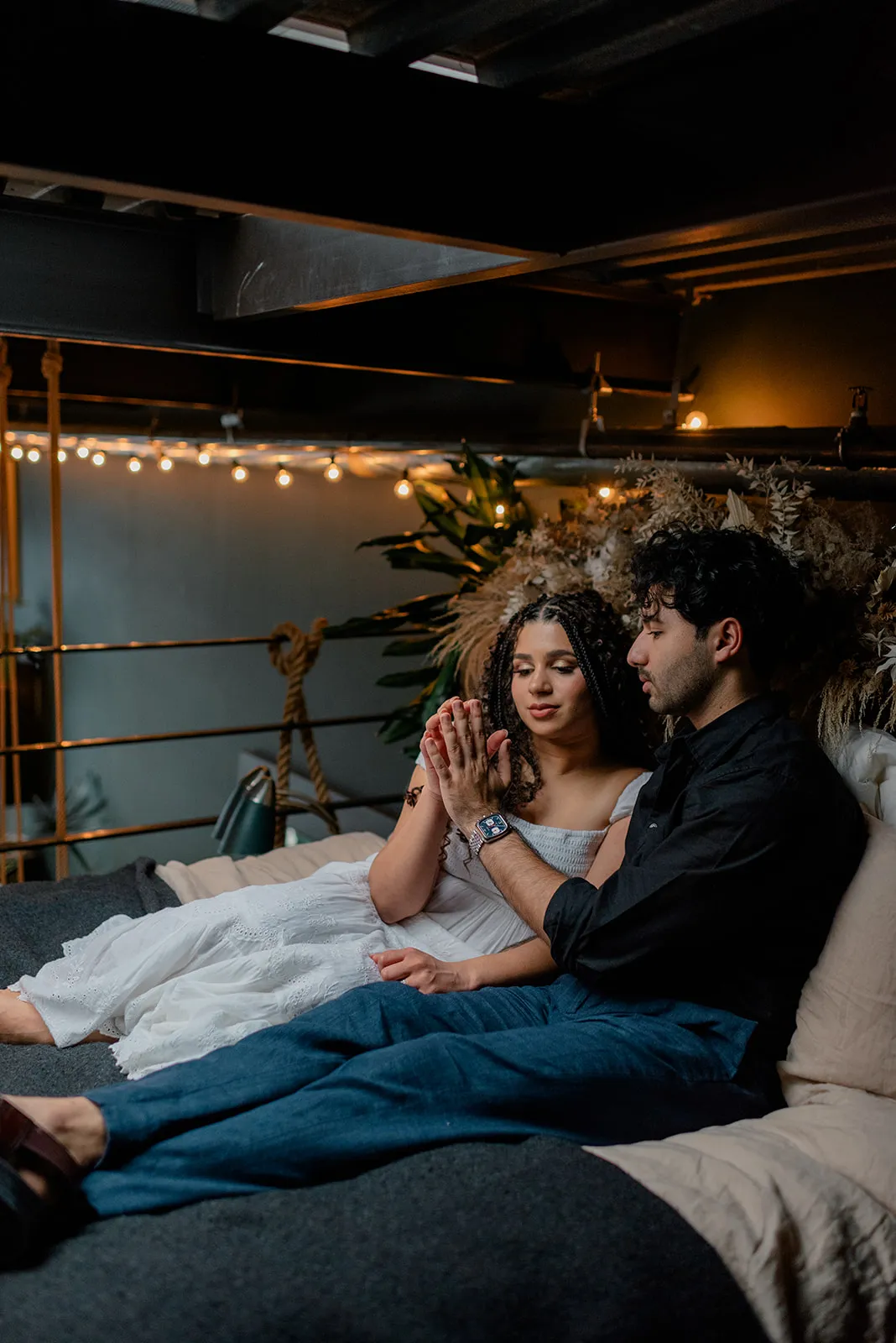 Stylish engagement photo of a couple framed by natural light and plants at Loft Garden Oasis, Vancouver’s top indoor studio