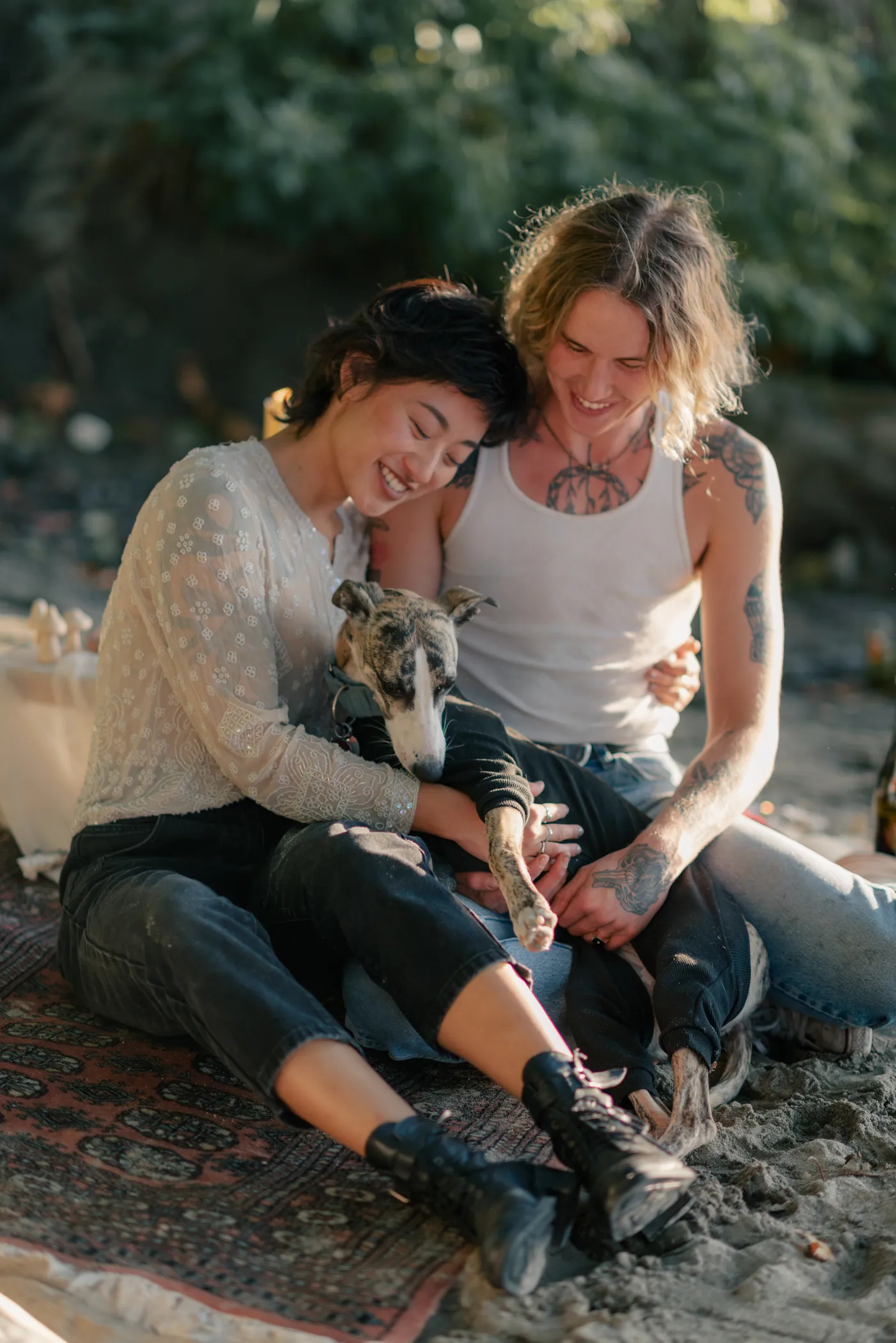 An adventurous LGBTQ+ couple with their dog enjoying a champagne toast in nature. A heartwarming post-proposal celebration by a Canadian queer engagement photographer.