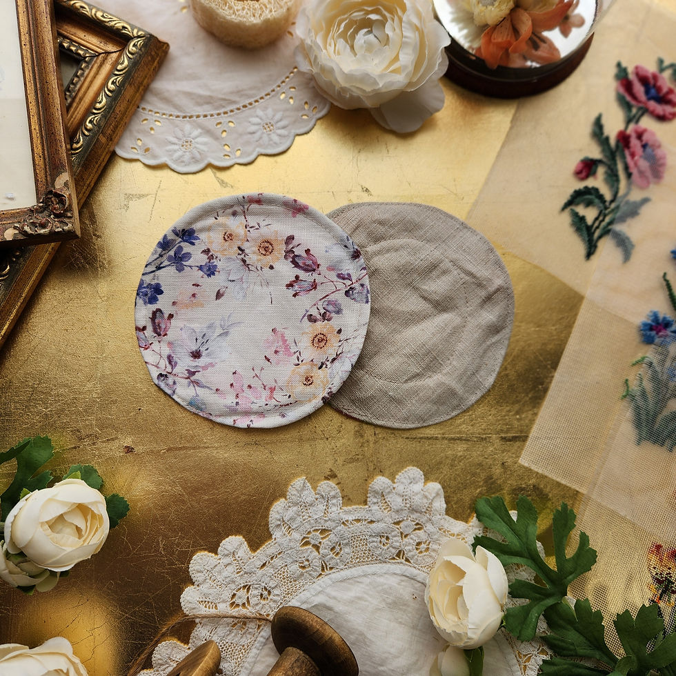Eye-level view of neatly folded linen nursing pads on a wooden surface
