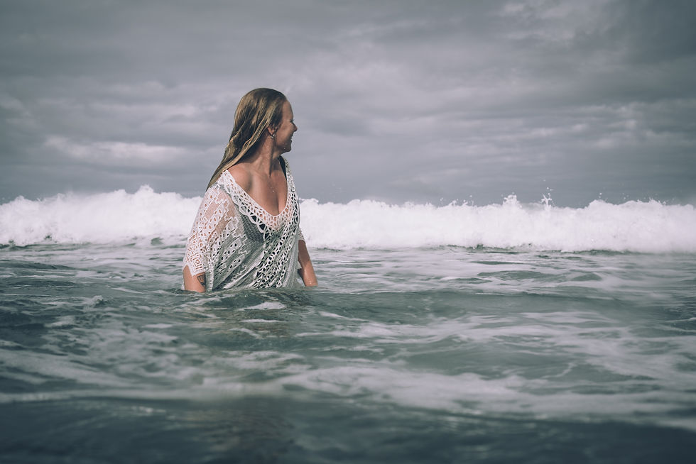 A woman standing in the sea with waves