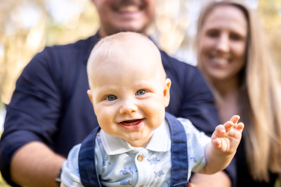 smiling baby being held by its parent during a family photography session