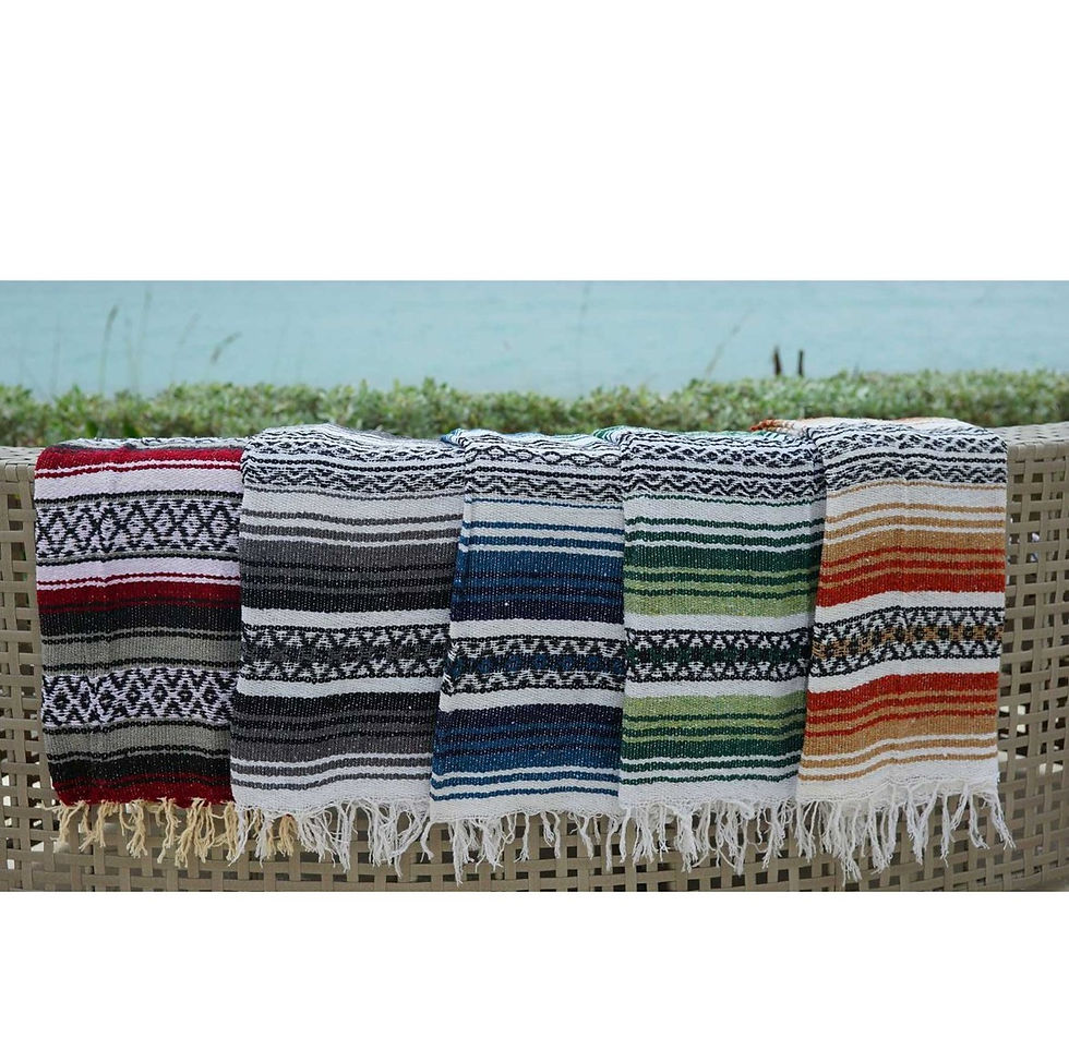 Colorful Baja Mexican blankets draped over outdoor bench with fringe detail