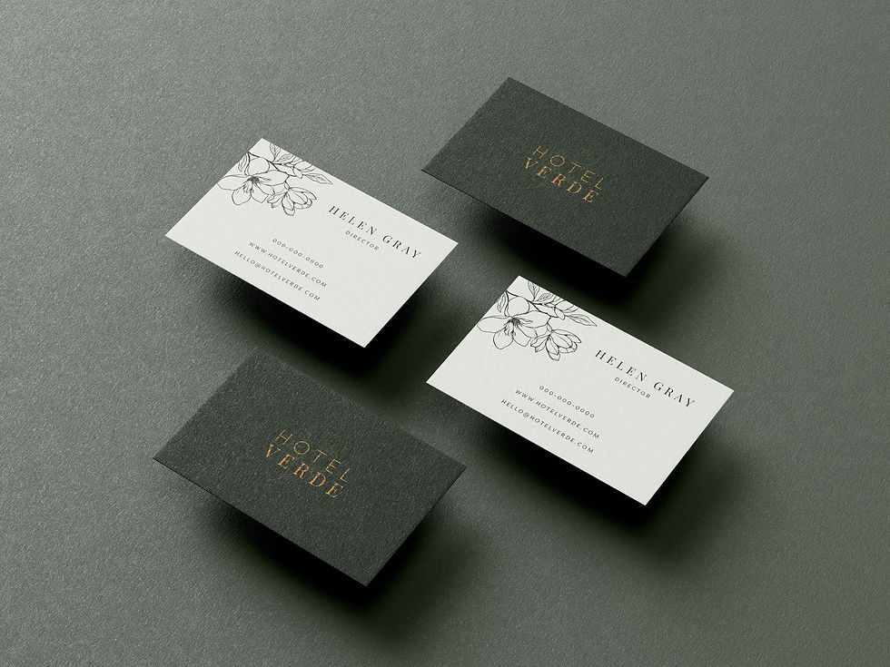 Business cards on textured surface — Hotel Verde visual identity featuring embossed gold logo.
