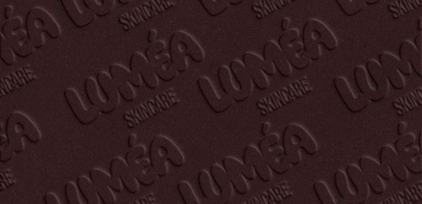 Luméa Skincare repeat pattern embossed on dark chocolate packaging material — luxury skincare brand identity by Studio Ruby Signorelli