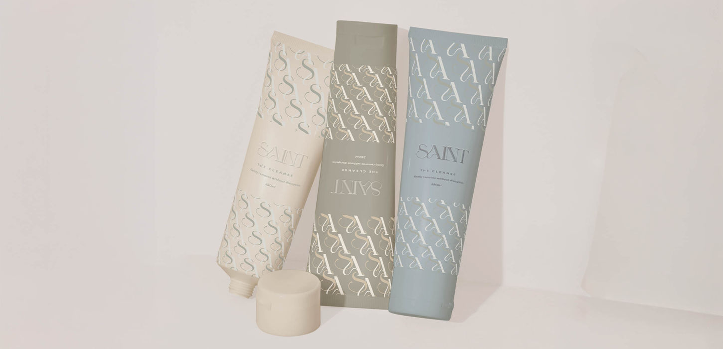 SAINT skincare cleanse tube range in cream sage and slate colorways with SA monogram pattern — luxury skincare packaging design by Studio Ruby Signorelli