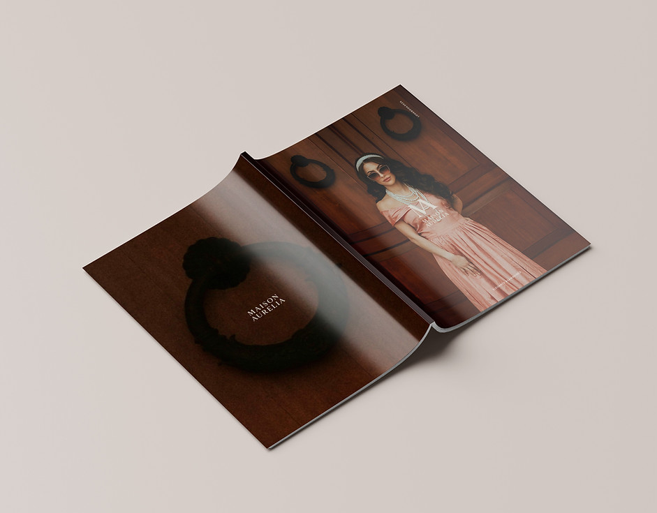 Magazine open to full-page image — cinematic fashion photography with elegant grid layout.