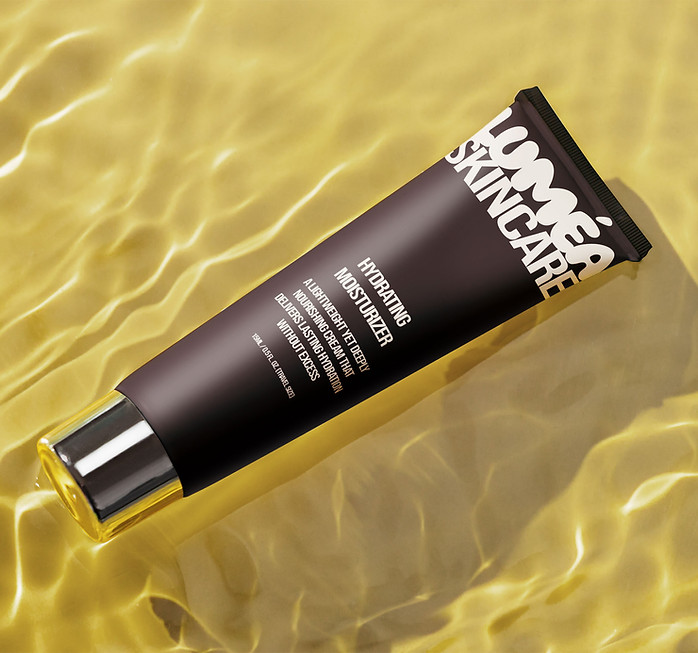 Flat-lay of luxury cosmetic tube on pale surface — refined product design aesthetic representing crafted detail.