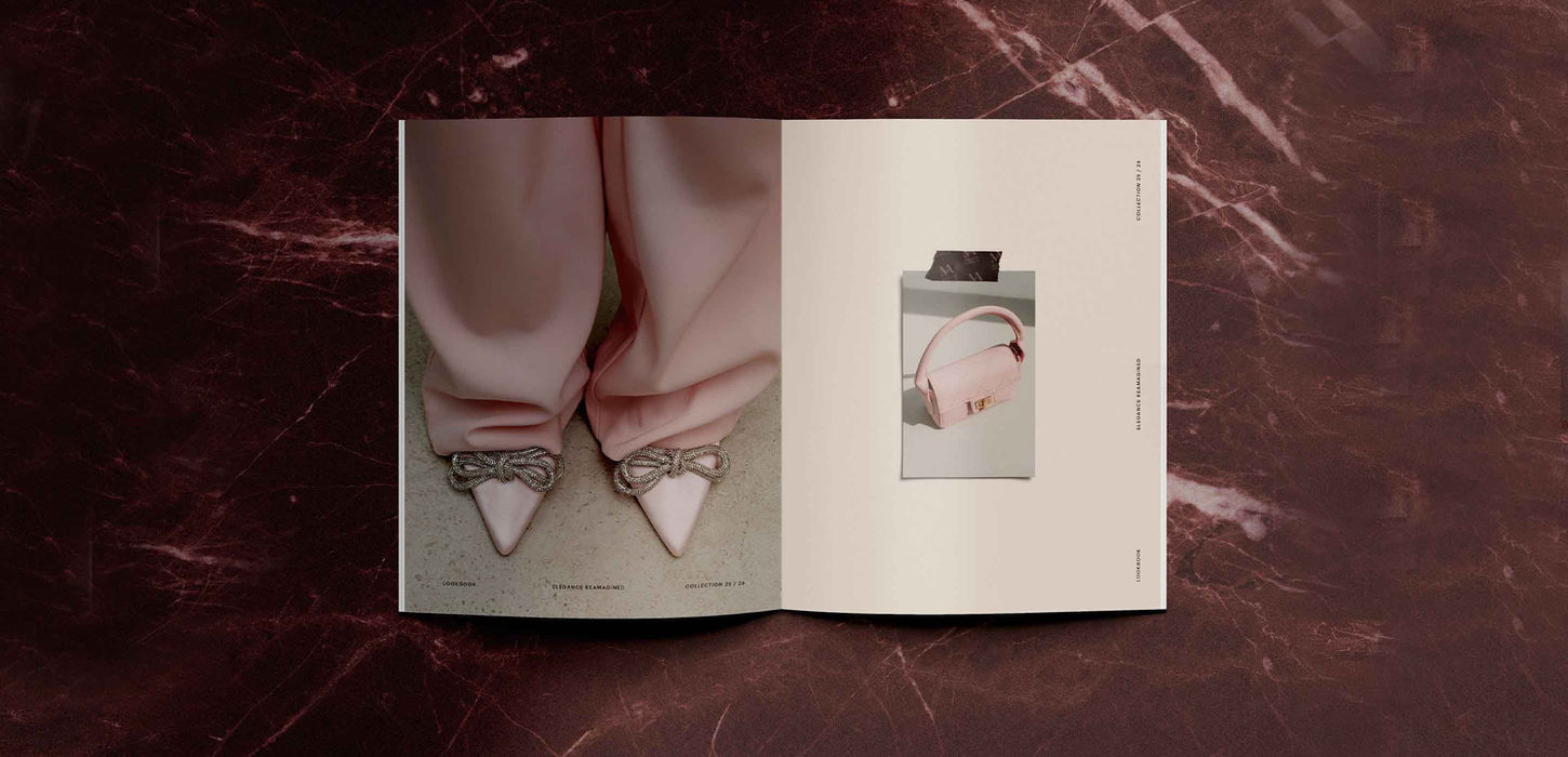 Maison Aurélia lookbook open showing fashion editorial spread on marble surface — luxury fashion lookbook design by Studio Ruby Signorelli