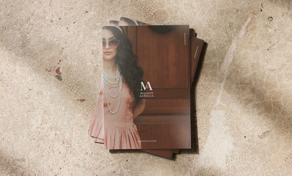 Stack of Maison Aurélia magazines on textured surface — refined editorial design for luxury fashion brand.
