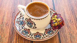 Turkish coffee in a tiny cup with a cookie.