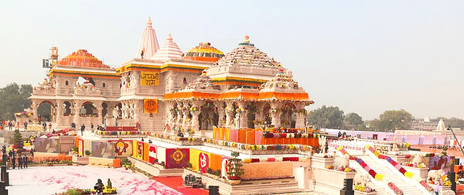 Ayodhya_Ram_Mandir_Inauguration_Day_The image shows a large white marble temple with intricate carvings and designs. It is surrounded by a large crowd of people.